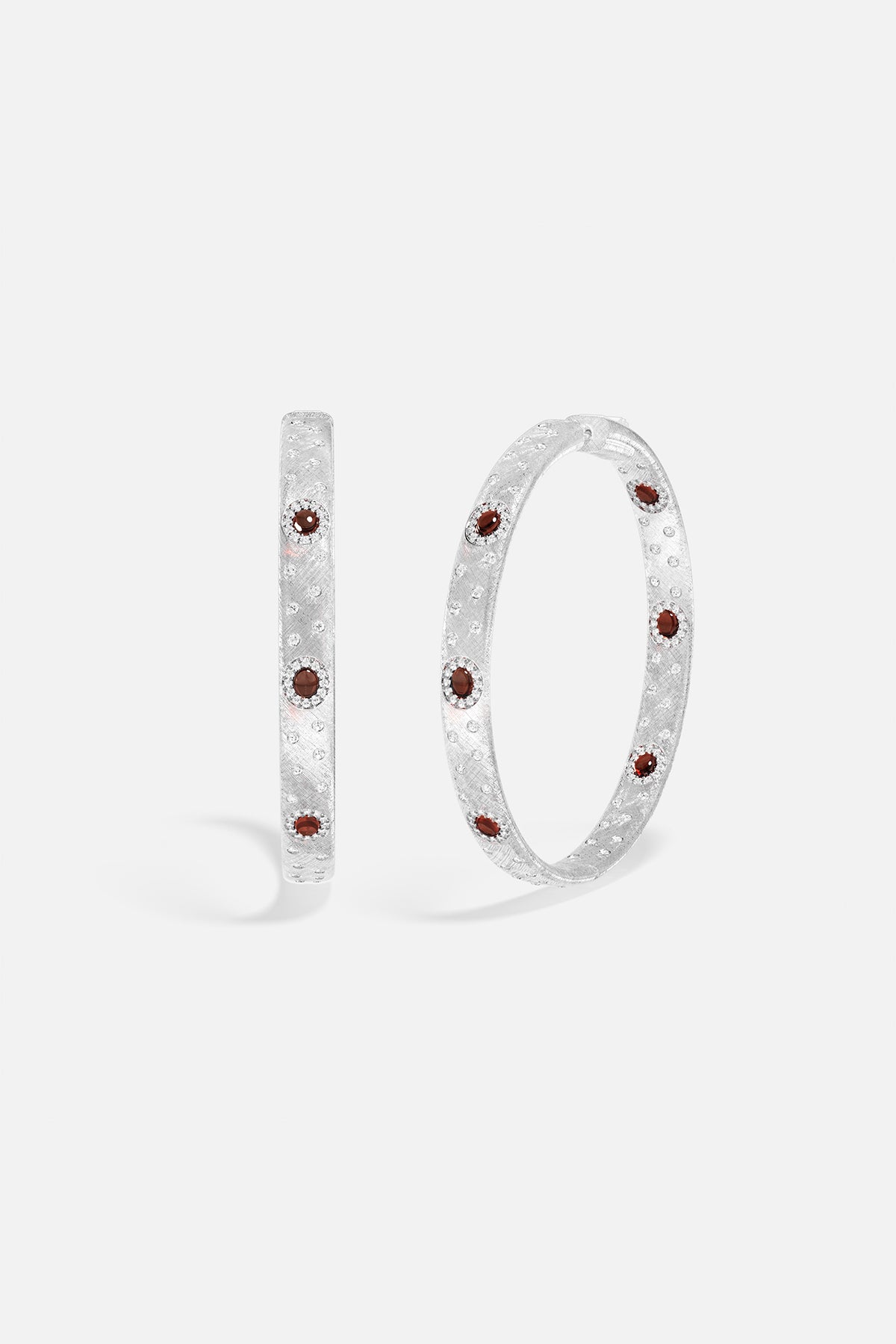 Créoles APM, finition rhodium constellée de touches rouges profondes, éclat intemporel.
