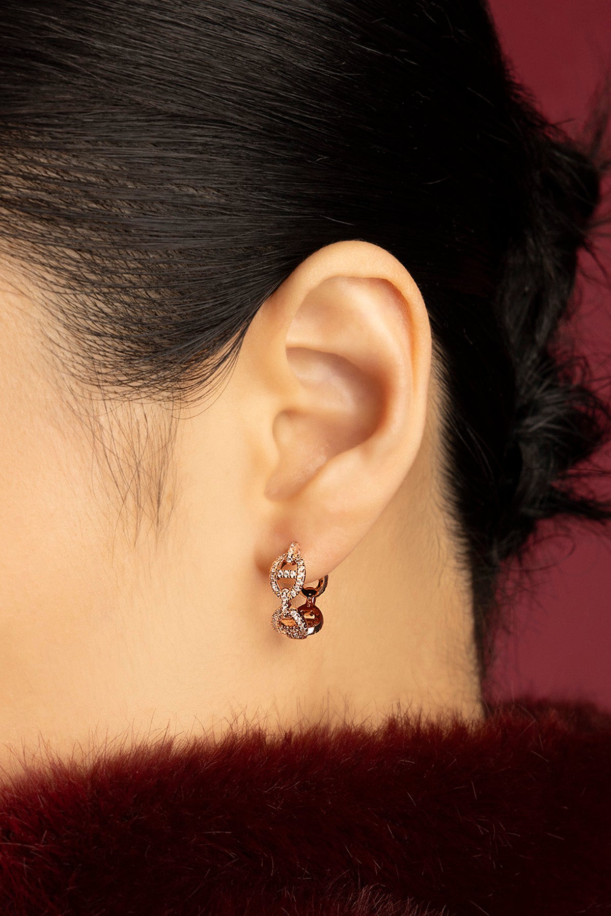 Femme portant les Boucles d'oreilles APM, une élégance dorée pleine de charme contemporain.