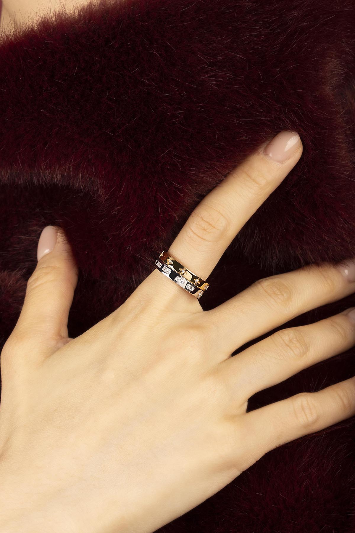 Woman wearing APM Morse Rings, une élégance discrète posée sur la fourrure bordeaux.