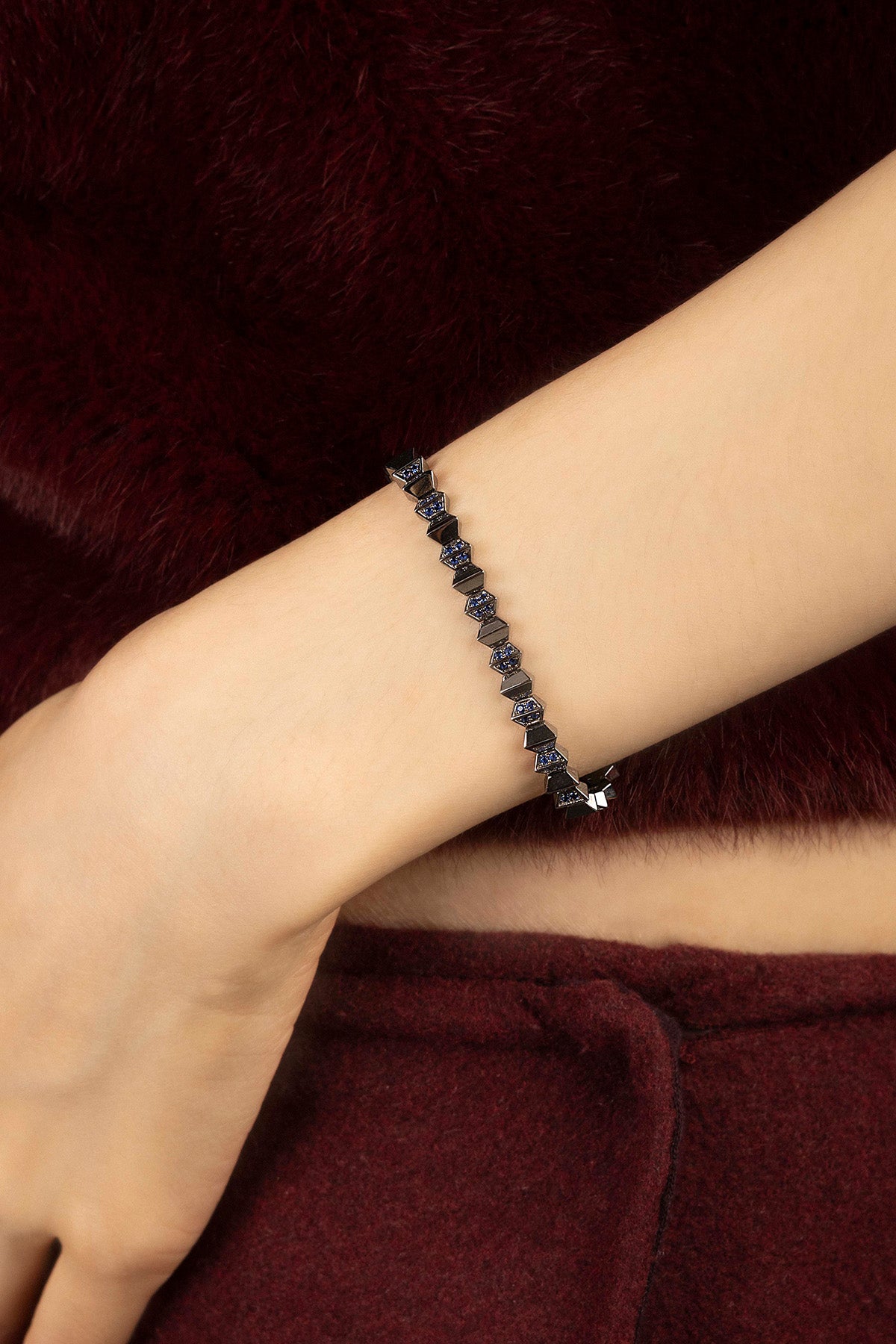 Femme portant le bracelet APM Monaco, éclat bleu nuit sur finition rhodium, allure audacieuse et raffinée.