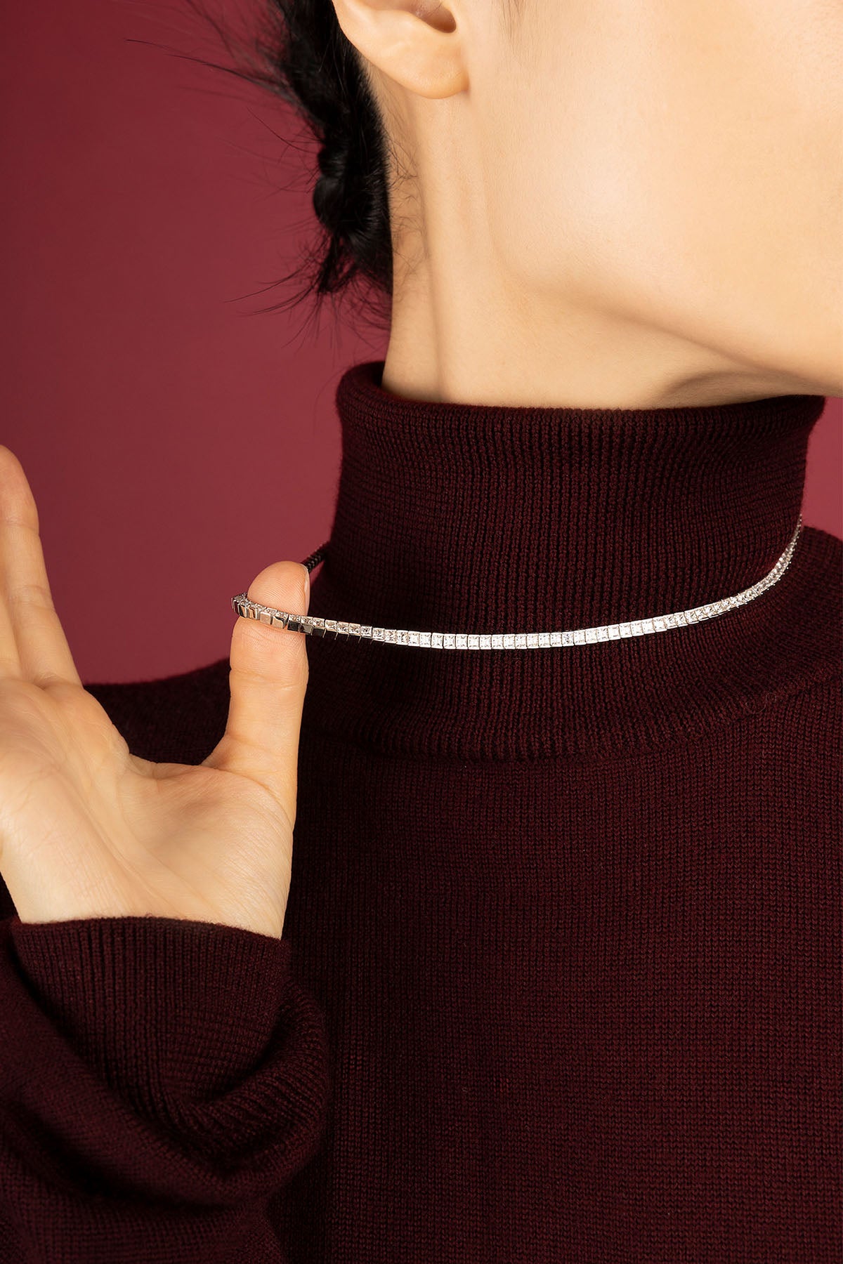 Femme portant le collier APM, éclat scintillant sur un col hivernal profond.