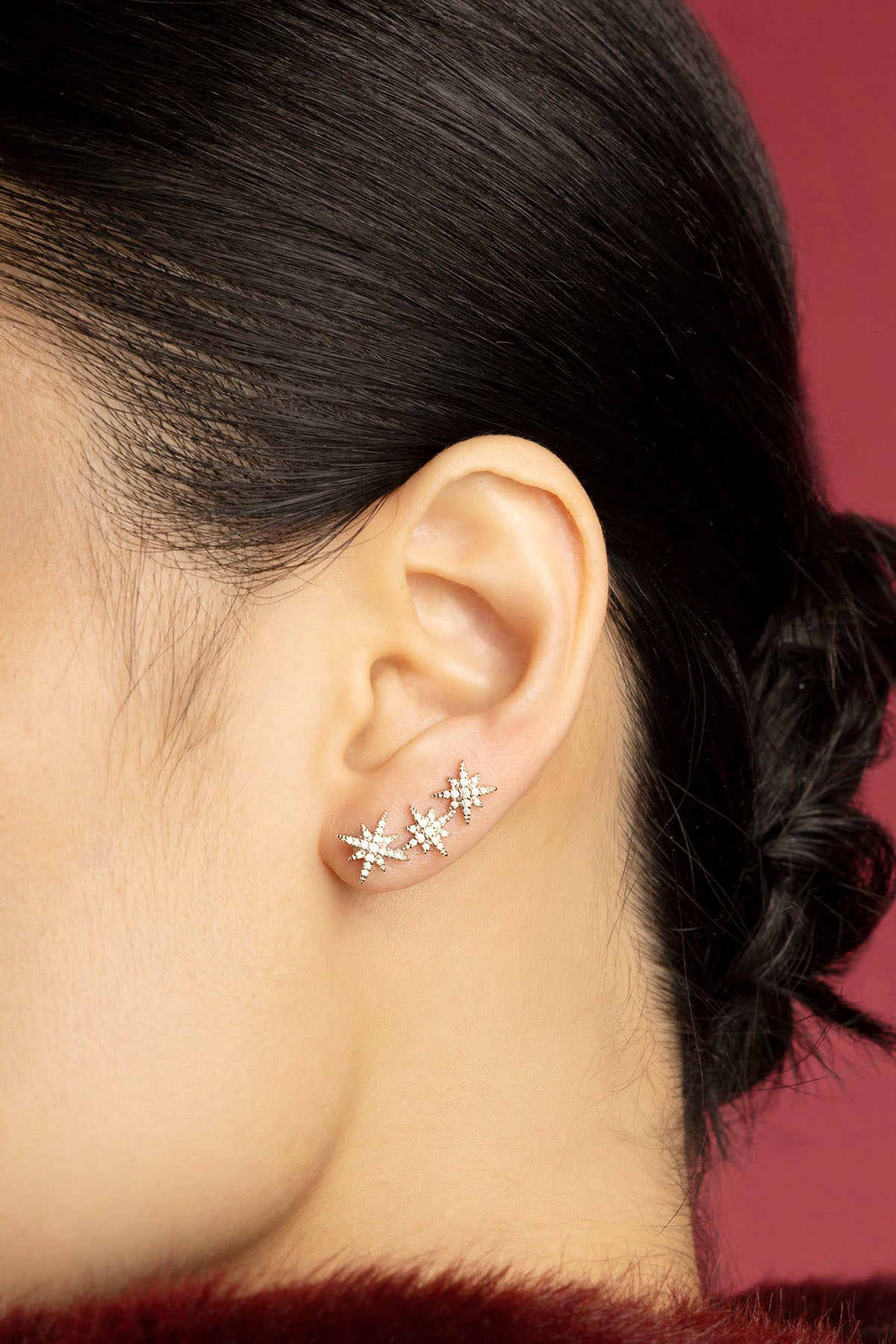 Femme portant les boucles d'oreilles étoiles APM Monaco, une constellation scintillante et délicatement féminine.