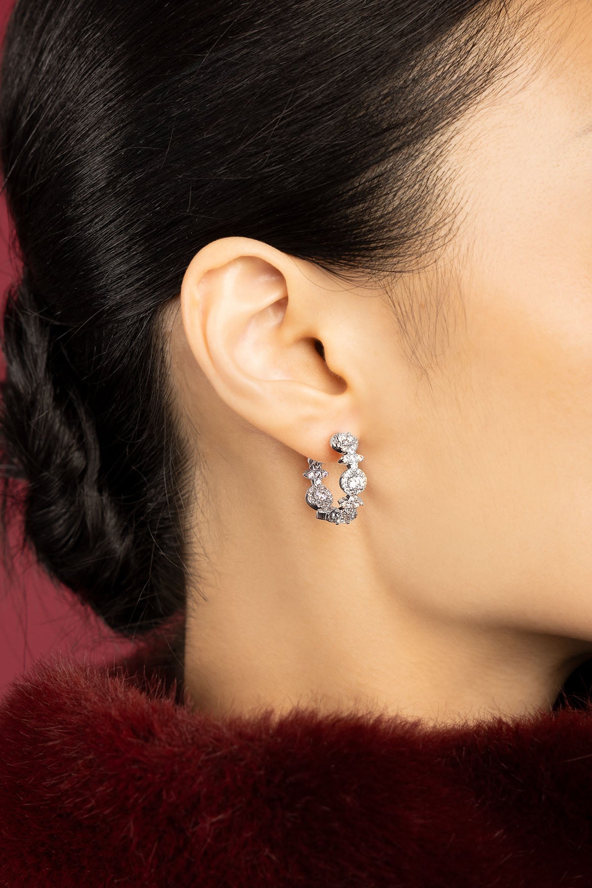 Woman wearing APM Monaco hoop earrings, une lueur scintillante posée sur la peau.