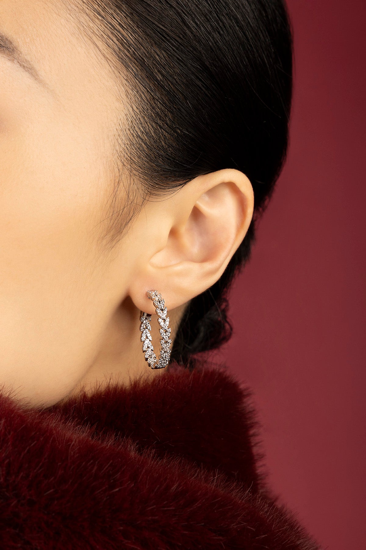Femme portant les Créoles APM, éclat scintillant sur une élégance feutrée.