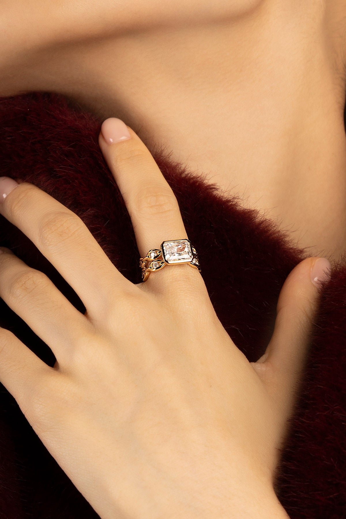 Femme portant la Bague APM Monaco, éclat doré et allure précieuse sur fourrure bordeaux.