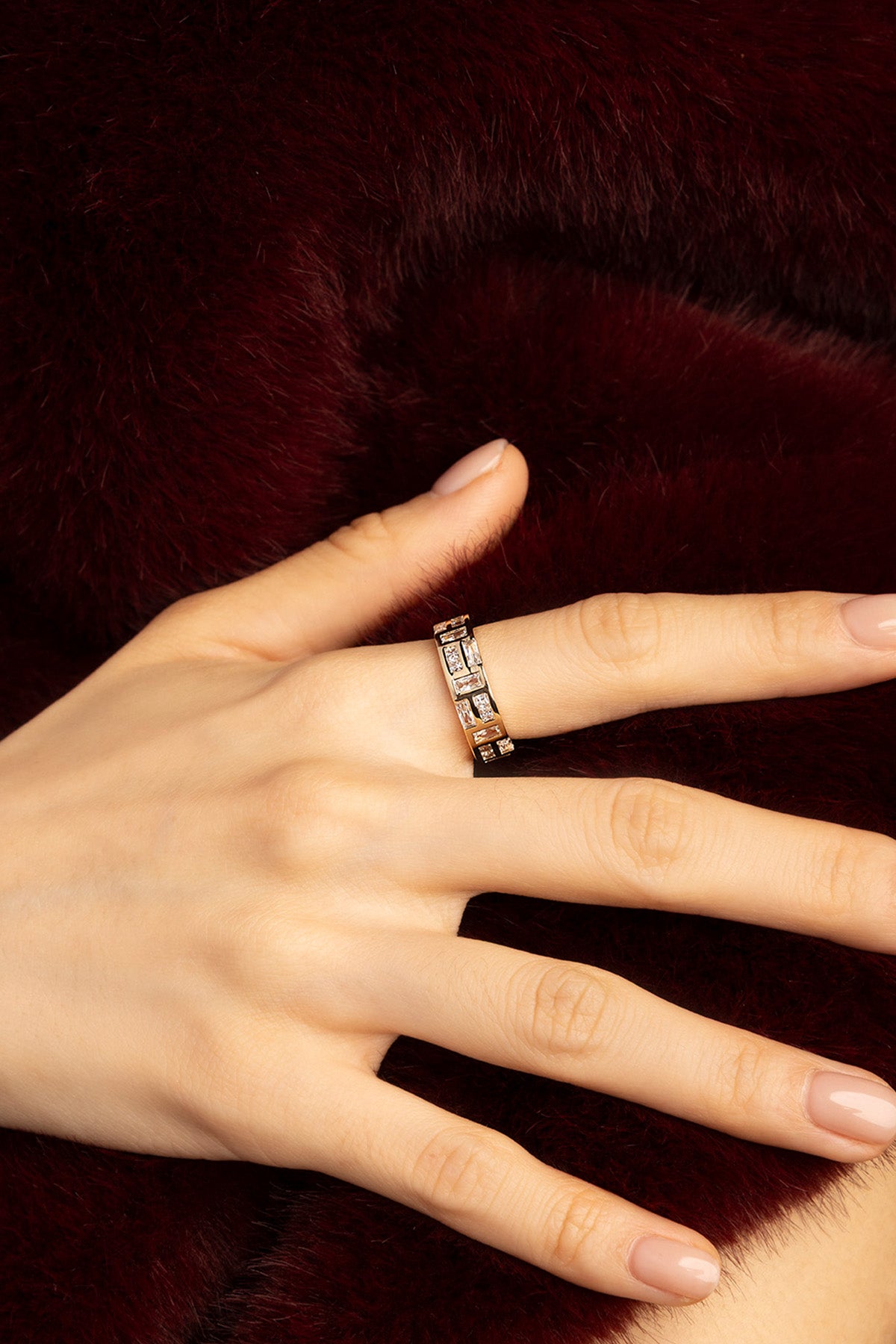 Femme portant la Bague APM Monaco, éclat doré et lumière graphique sur fourrure profonde.