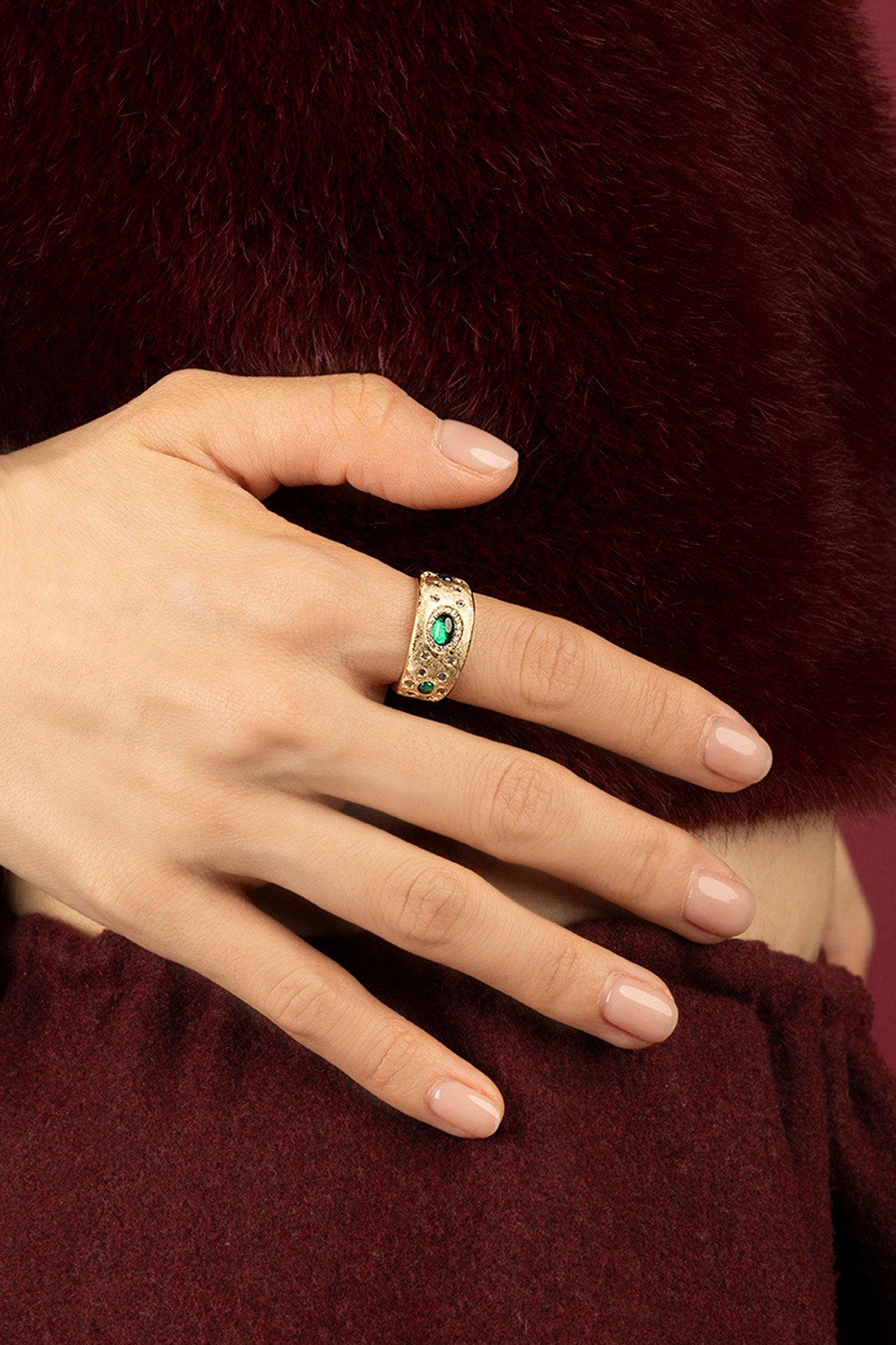 Femme portant la bague APM Monaco à pierre verte, élégance chaleureuse et intemporelle.