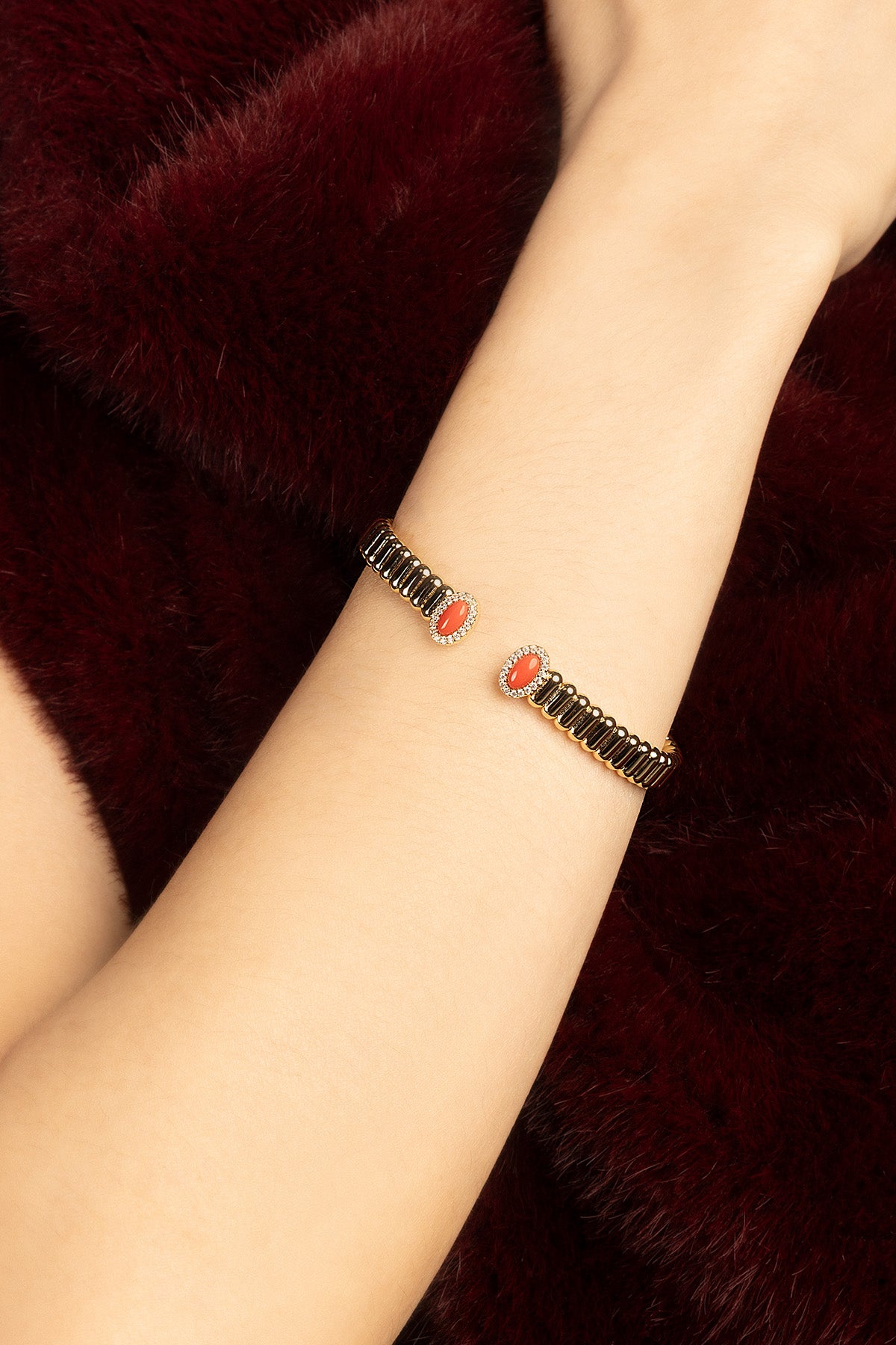 Femme portant le Bracelet APM, deux touches corail pour une élégance chaleureuse et contemporaine.