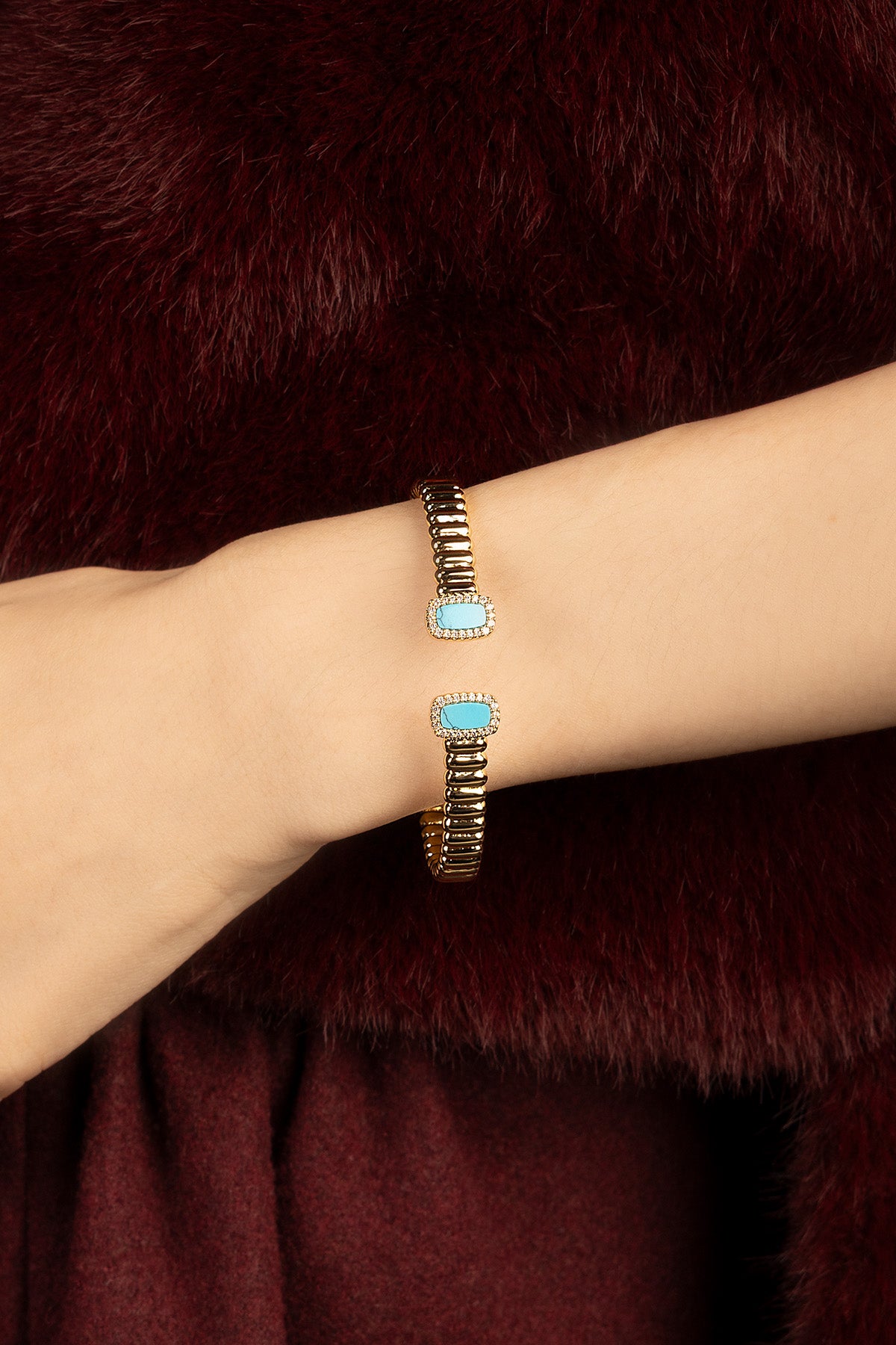 Woman wearing APM bracelet jonc, touches turquoise et éclat doré, allure résolument chic.