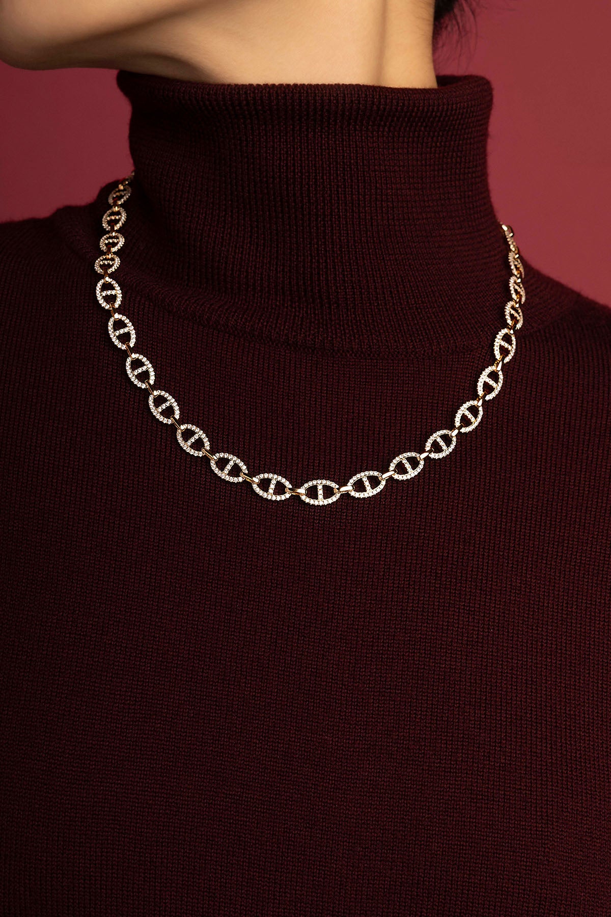 Woman wearing Collier Morse APM, éclat scintillant sur un col bordeaux hivernal.
