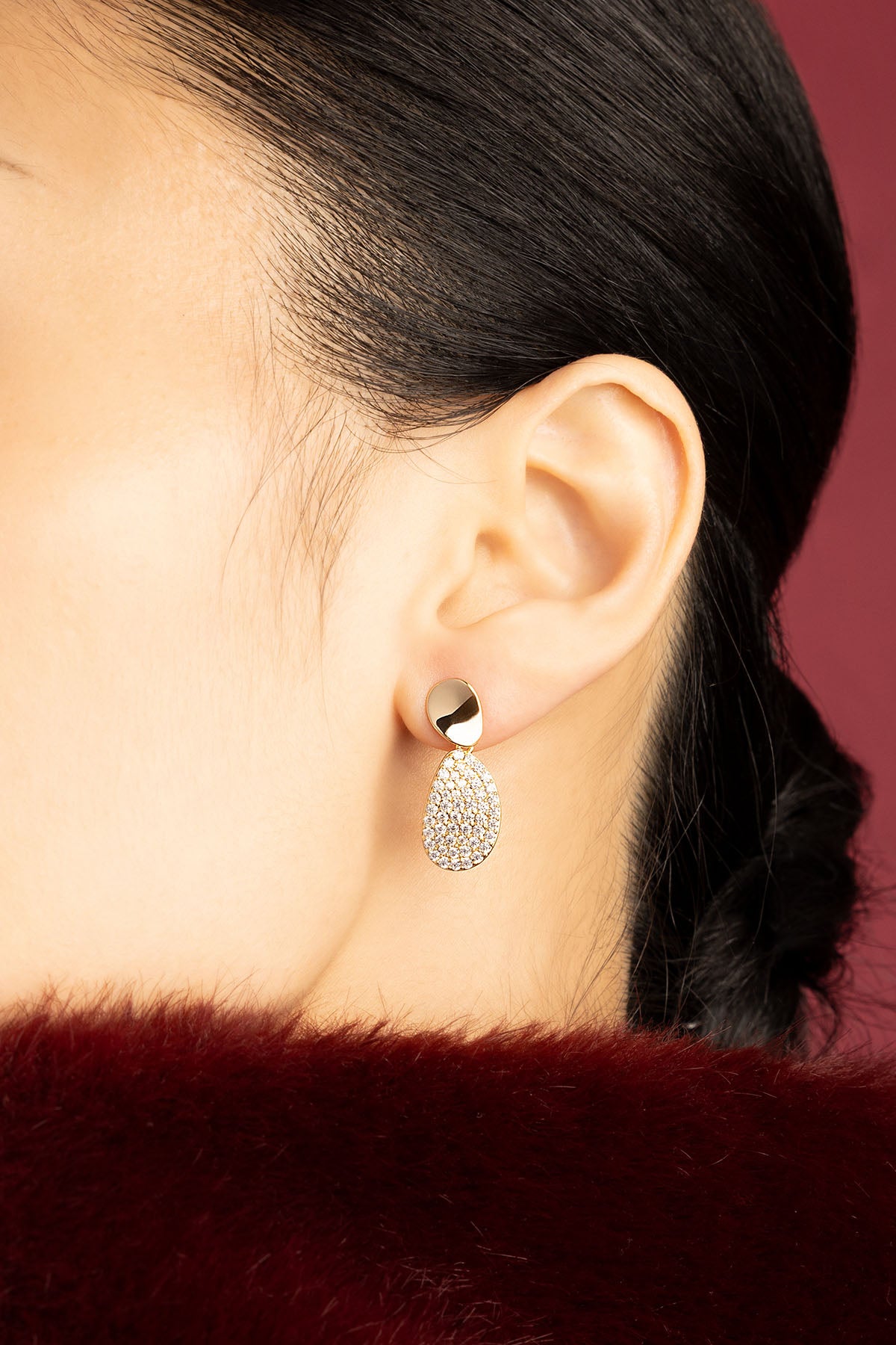 Femme portant des Boucles d'Oreilles APM, éclat doré et lumière scintillante, élégance intemporelle.