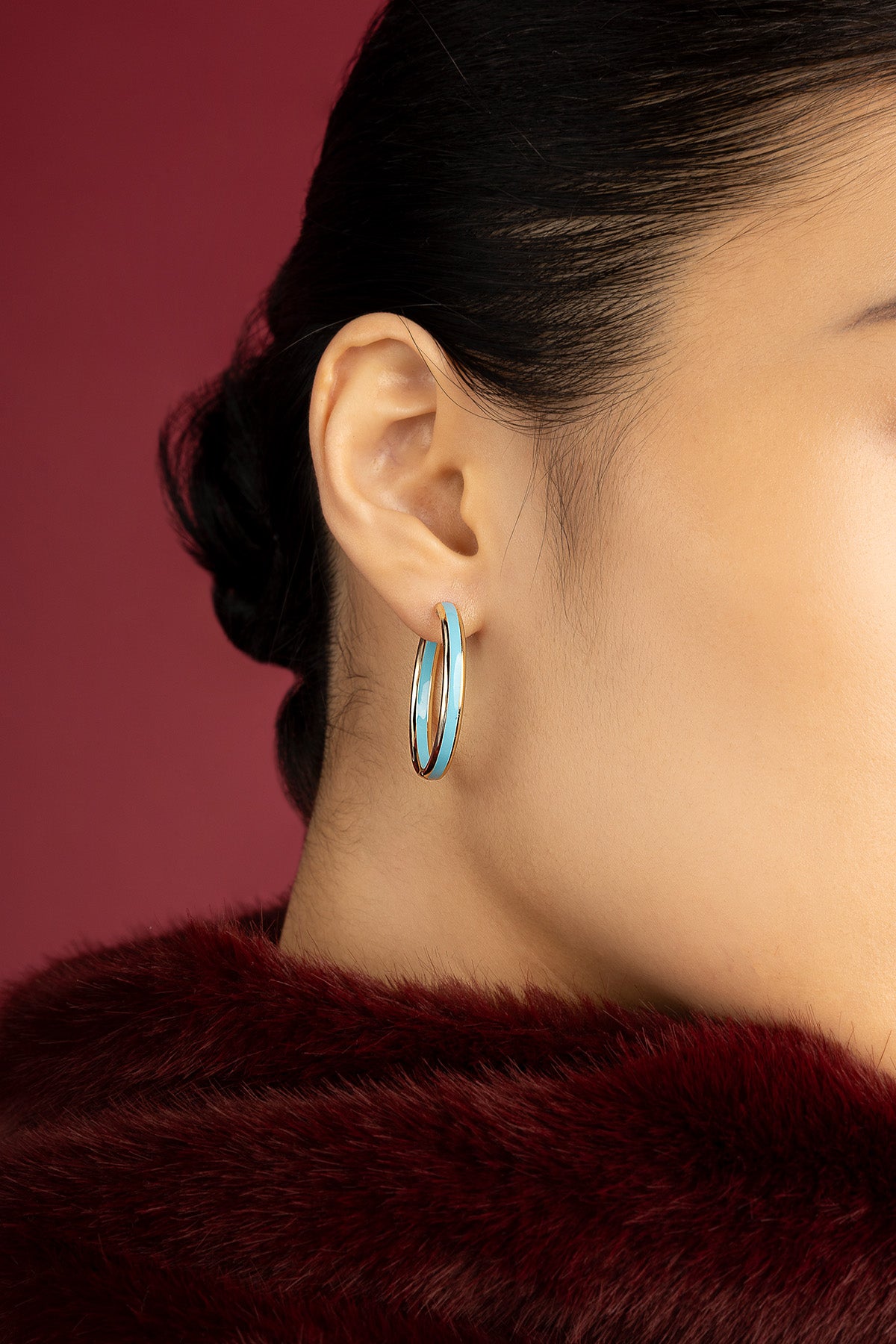Femme portant les créoles APM Monaco, touche turquoise pour une allure audacieuse et raffinée.
