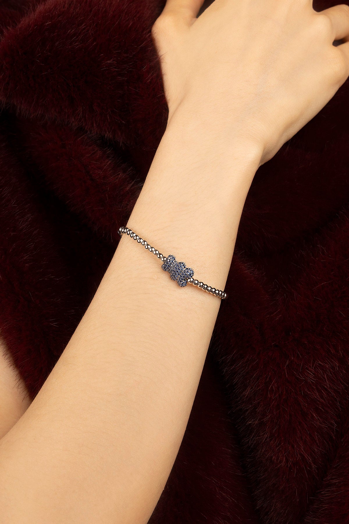 Femme portant le bracelet APM Monaco, éclat bleu délicat sur perles lumineuses.