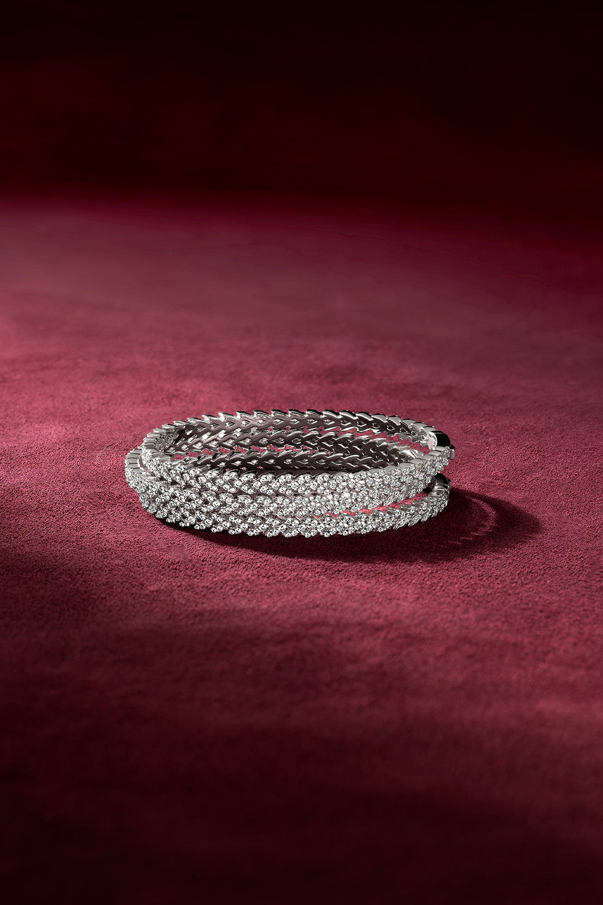 Bracelet APM Morse, éclat scintillant sur velours bordeaux, une élégance intemporelle.
