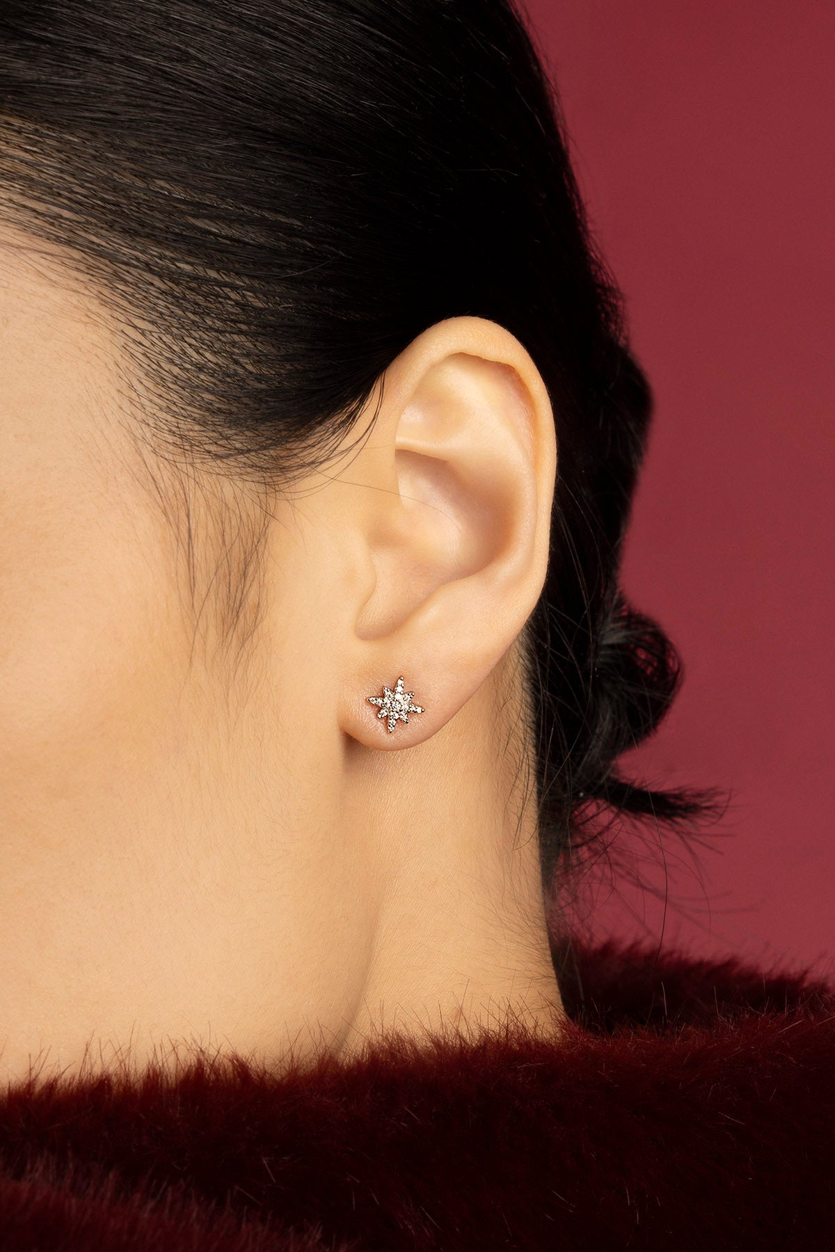 Femme portant les puces d'oreilles étoile APM Monaco, éclat délicat et intemporel.