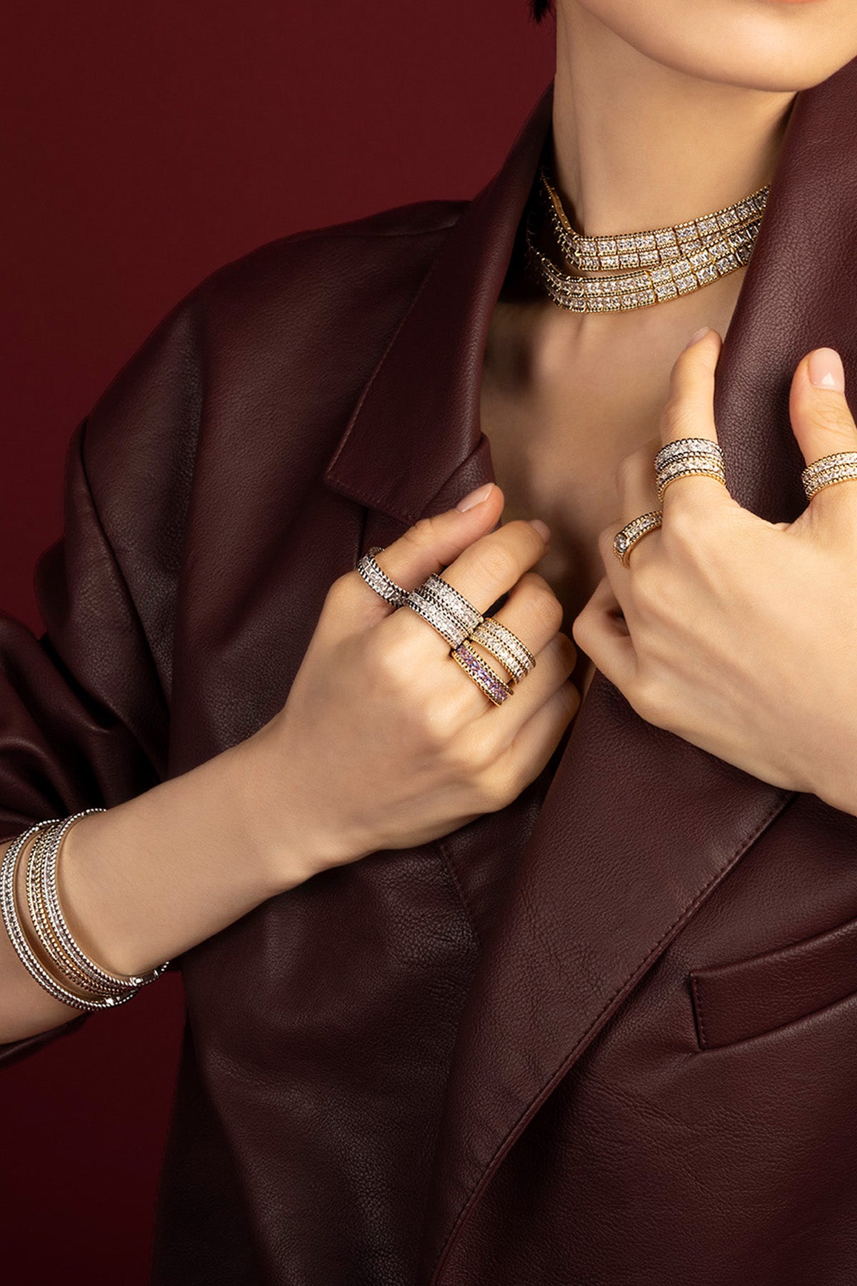 Femme portant les bijoux APM Monaco, éclat scintillant sur cuir bordeaux, allure audacieuse et raffinée.