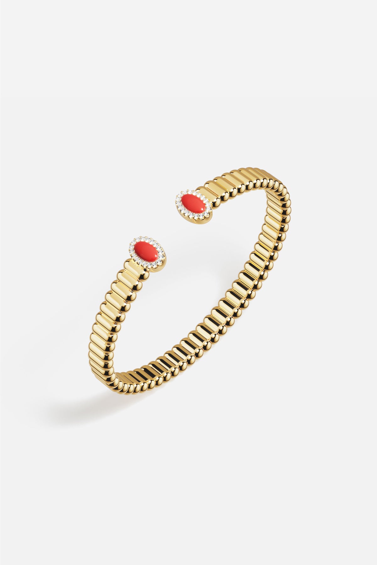 Bracelet APM doré, touches rouges lumineuses, une élégance sculpturale et solaire.