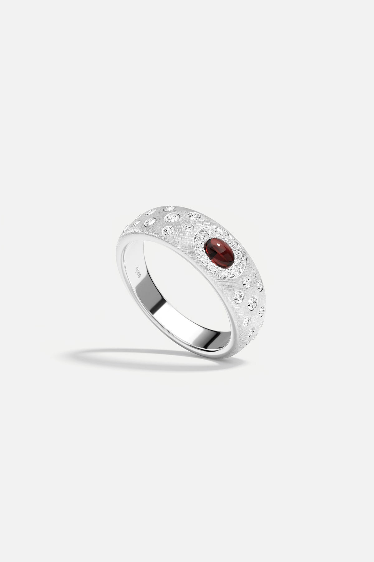 Bague APM, une pierre rouge intense sur finition rhodiée, élégance céleste.