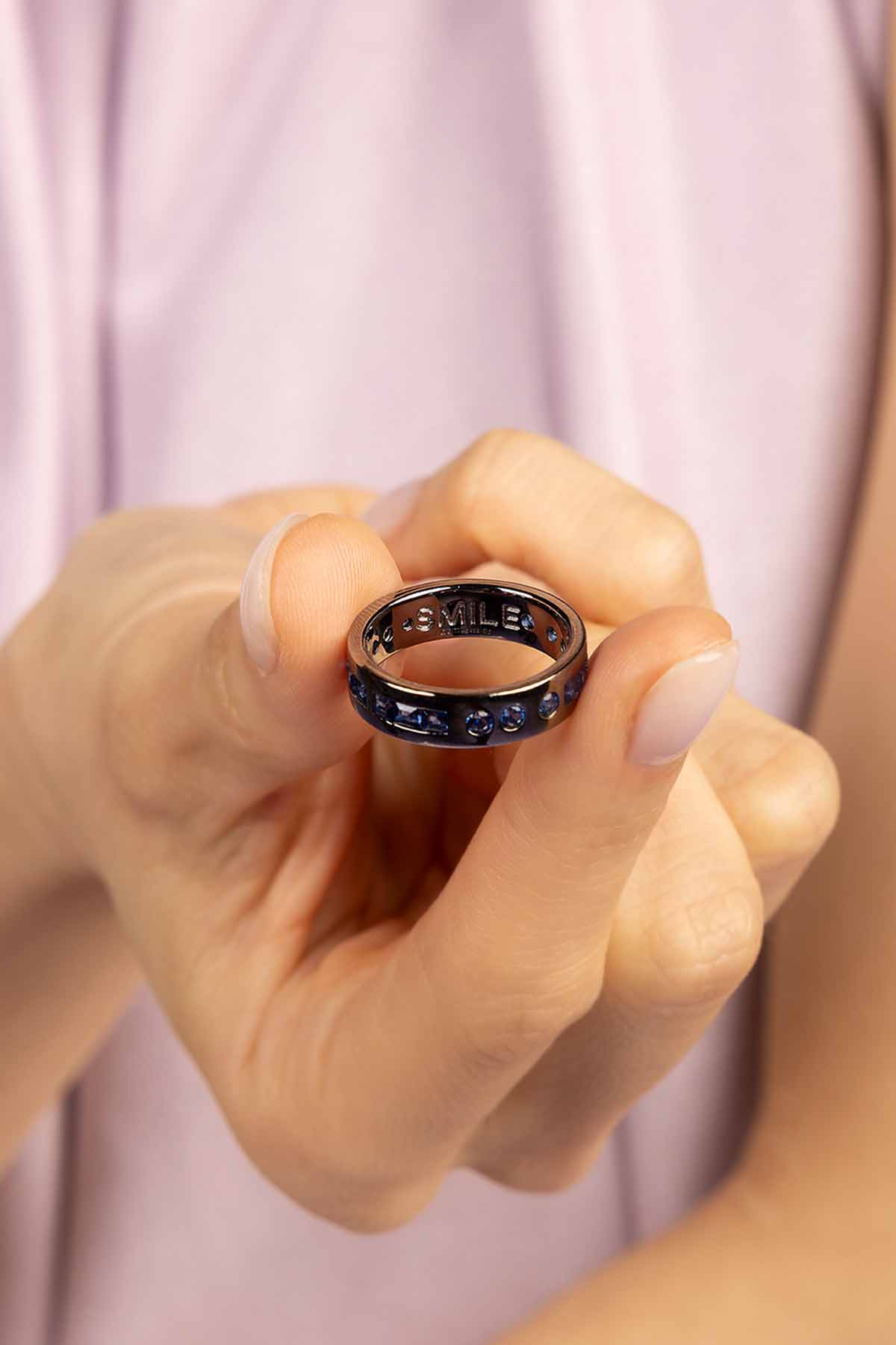 Rings APM Monaco. Silver ring with a row of blue gemstones on the top and 'SMILE' engraved inside.