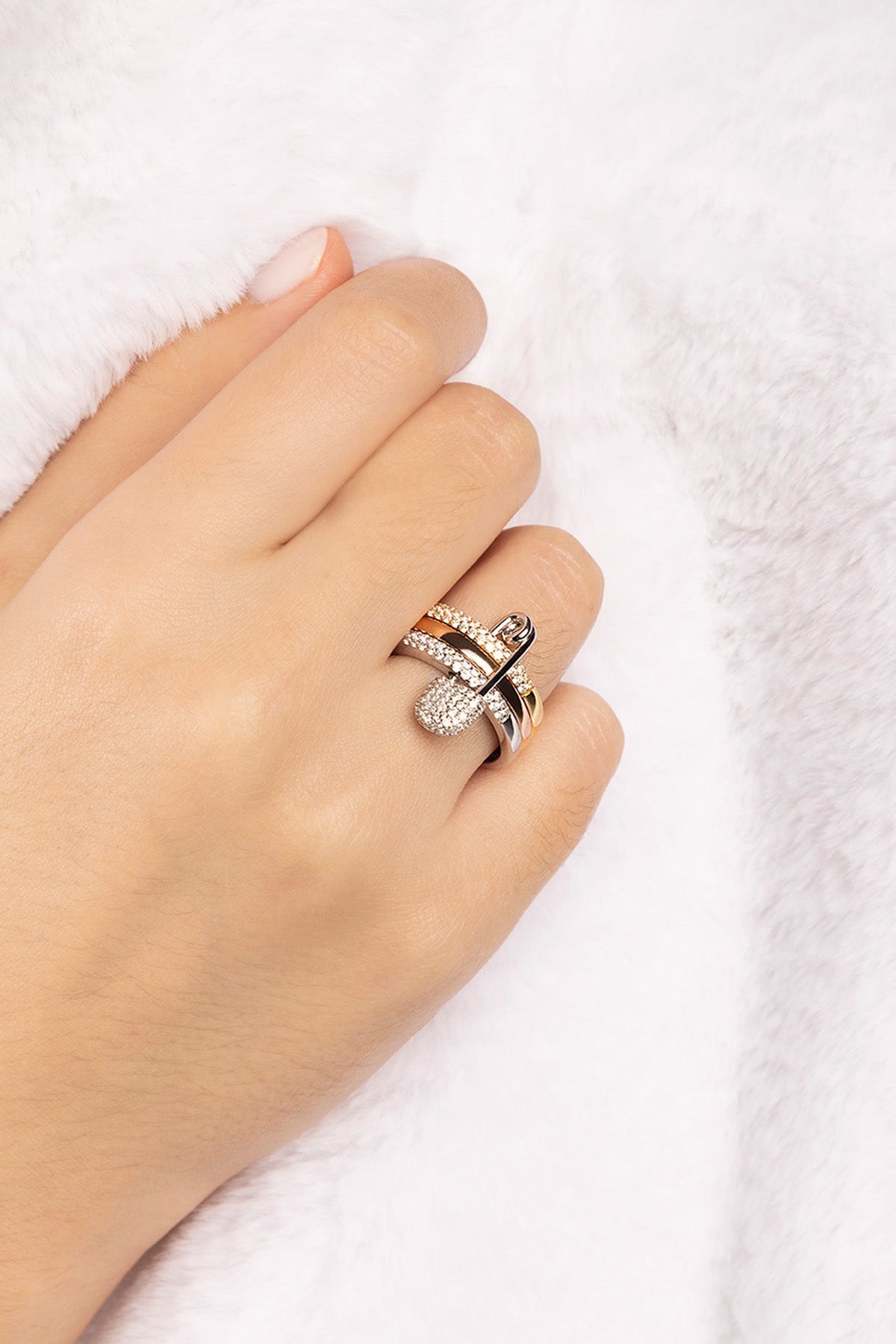 Rings APM Monaco fashion jewelry: a white, triple-hoop safety-pin ring with pavé cubic zirconia, paired with two additional cubic zirconia rings.