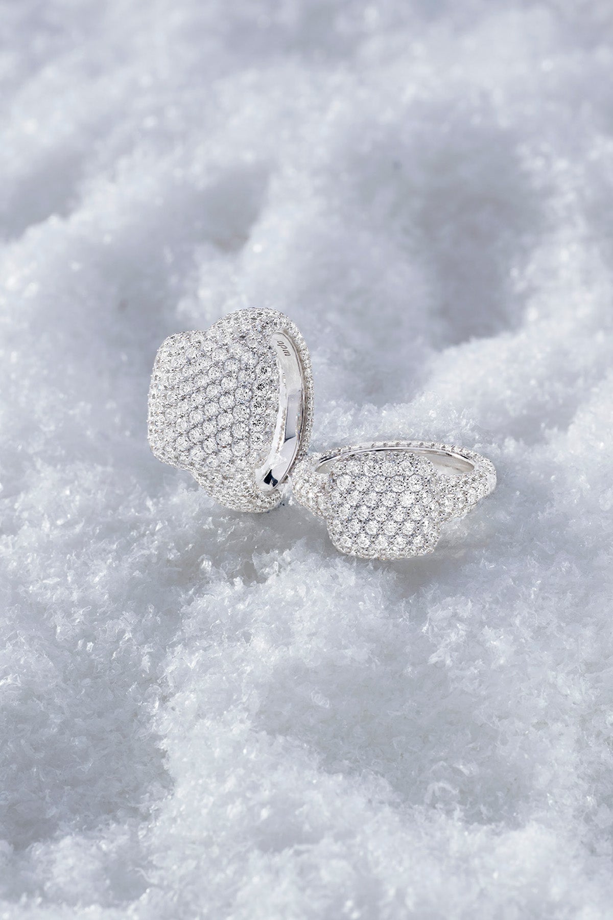 APM MONACO statement pave ring in silver on a textured white snow surface