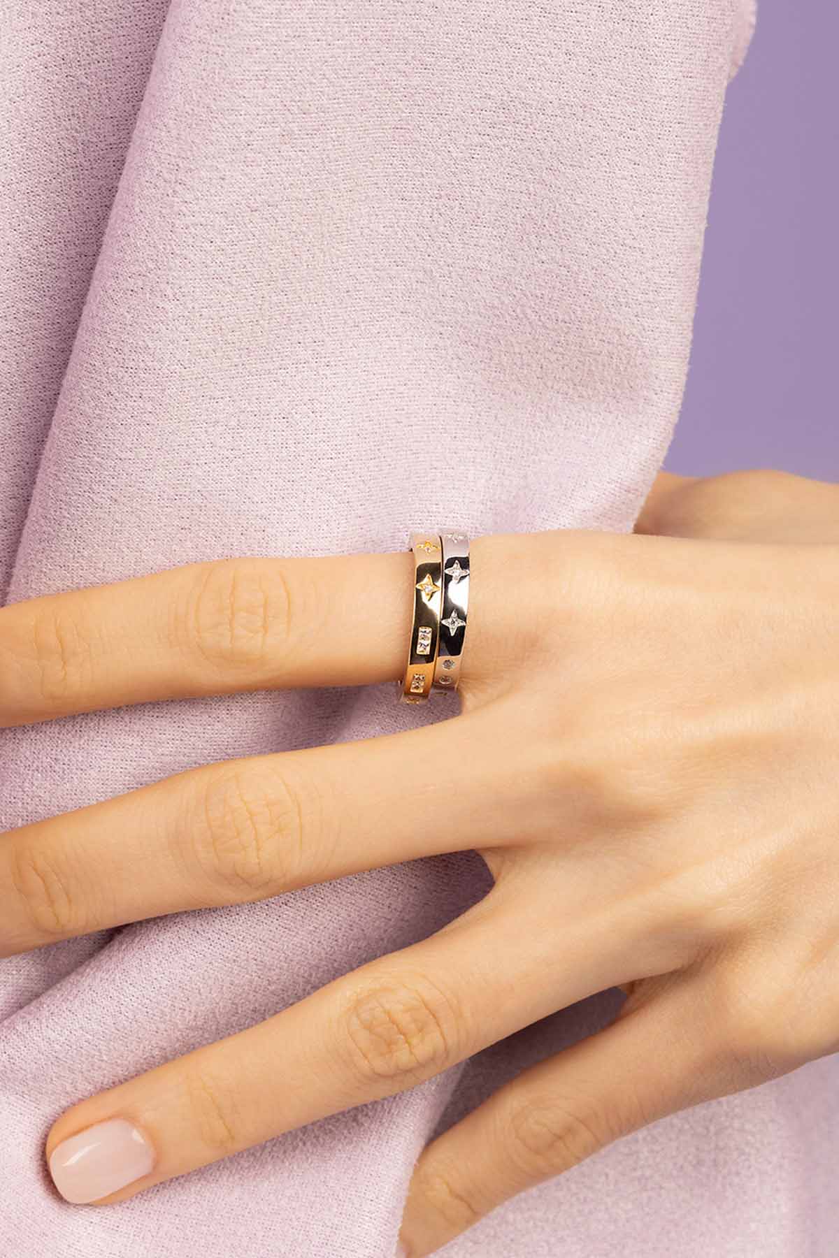 Hand wearing a gold ring on a white background