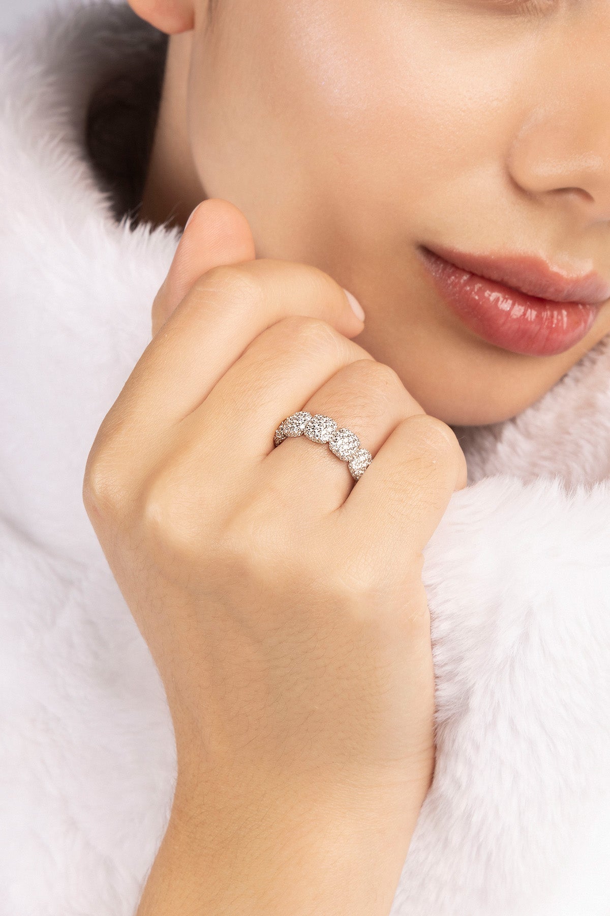 Close-up of a hand wearing a APM MONACO pave ring in silver with a white fur background