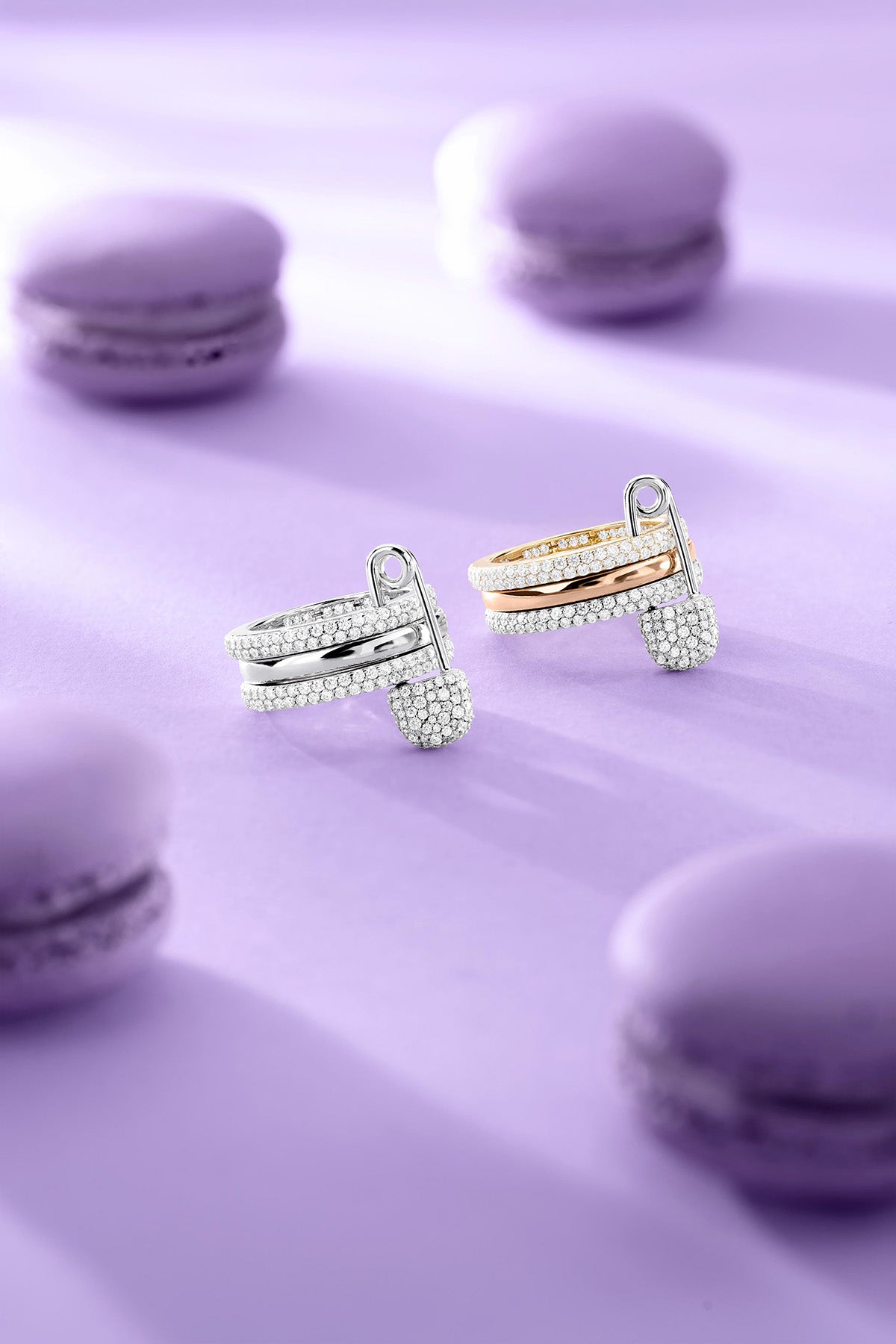 Rings APM Monaco fashion jewelry: a white, triple-hoop safety-pin ring with pavé cubic zirconia, paired with two additional cubic zirconia rings.
