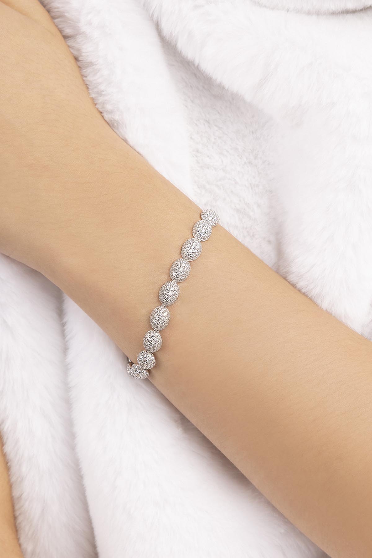 APM MONACO silver pave bracelet on a person's wrist against a white background