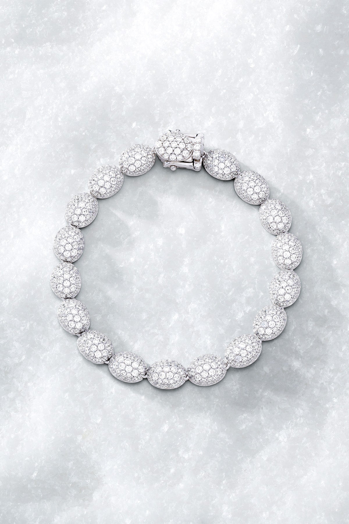 APM MONACO pave bracelet in silver with a textured design on a light grey surface