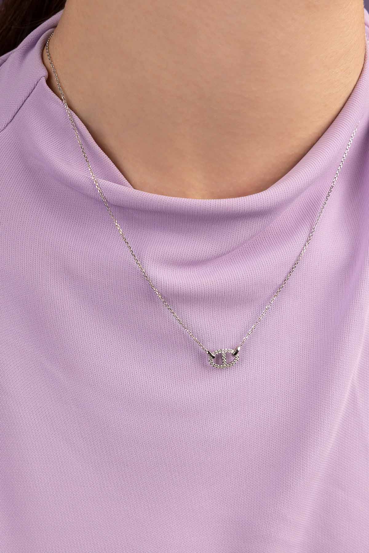 Necklaces APM Monaco, white silvertone chain with an interlocking circle pendant encrusted with pavé stones.