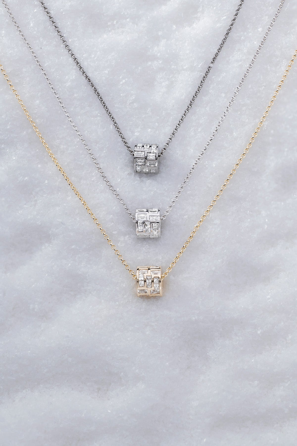 Three APM MONACO labyrinth adjustable chokers on soft white surface