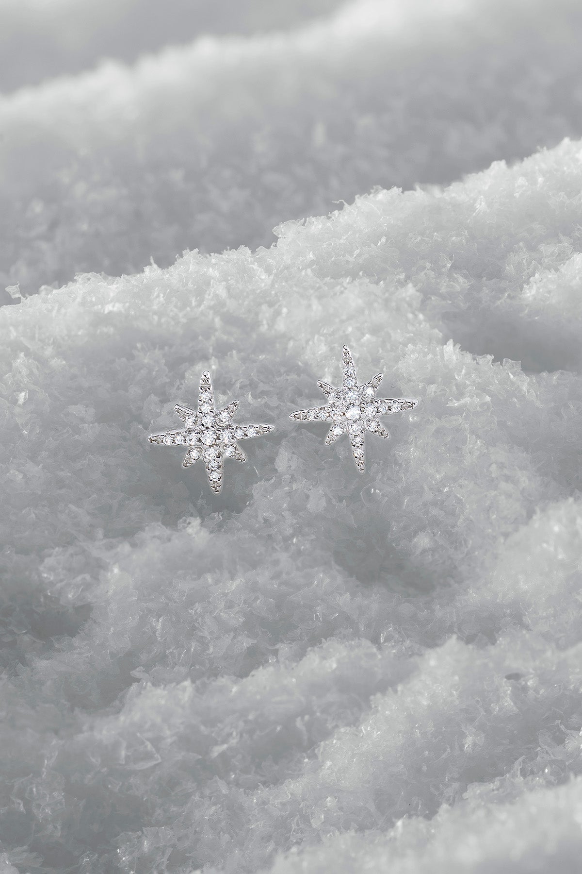 Star-shaped earrings on a snowy background