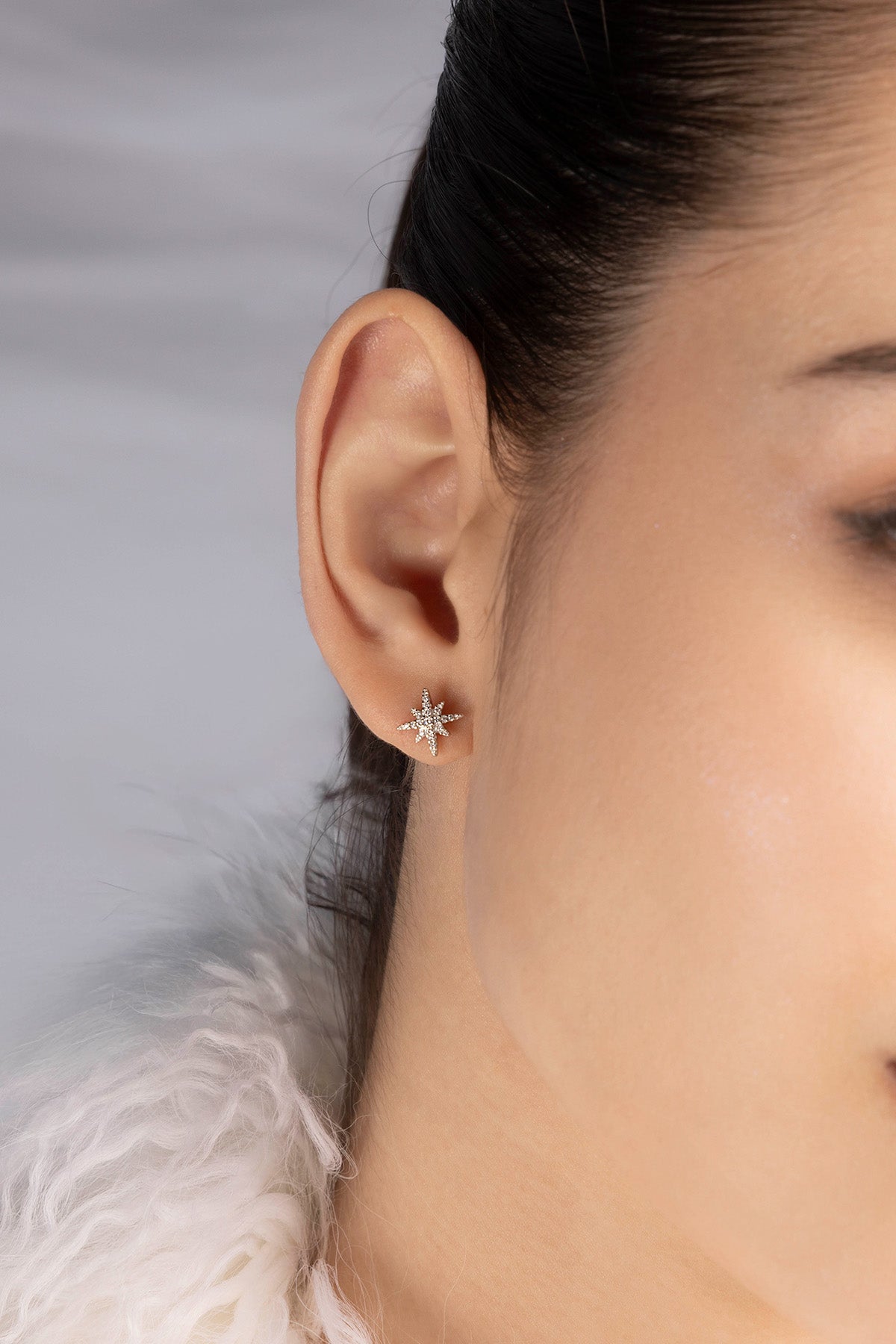 Closeup of an ear wearing a earring with a soft background