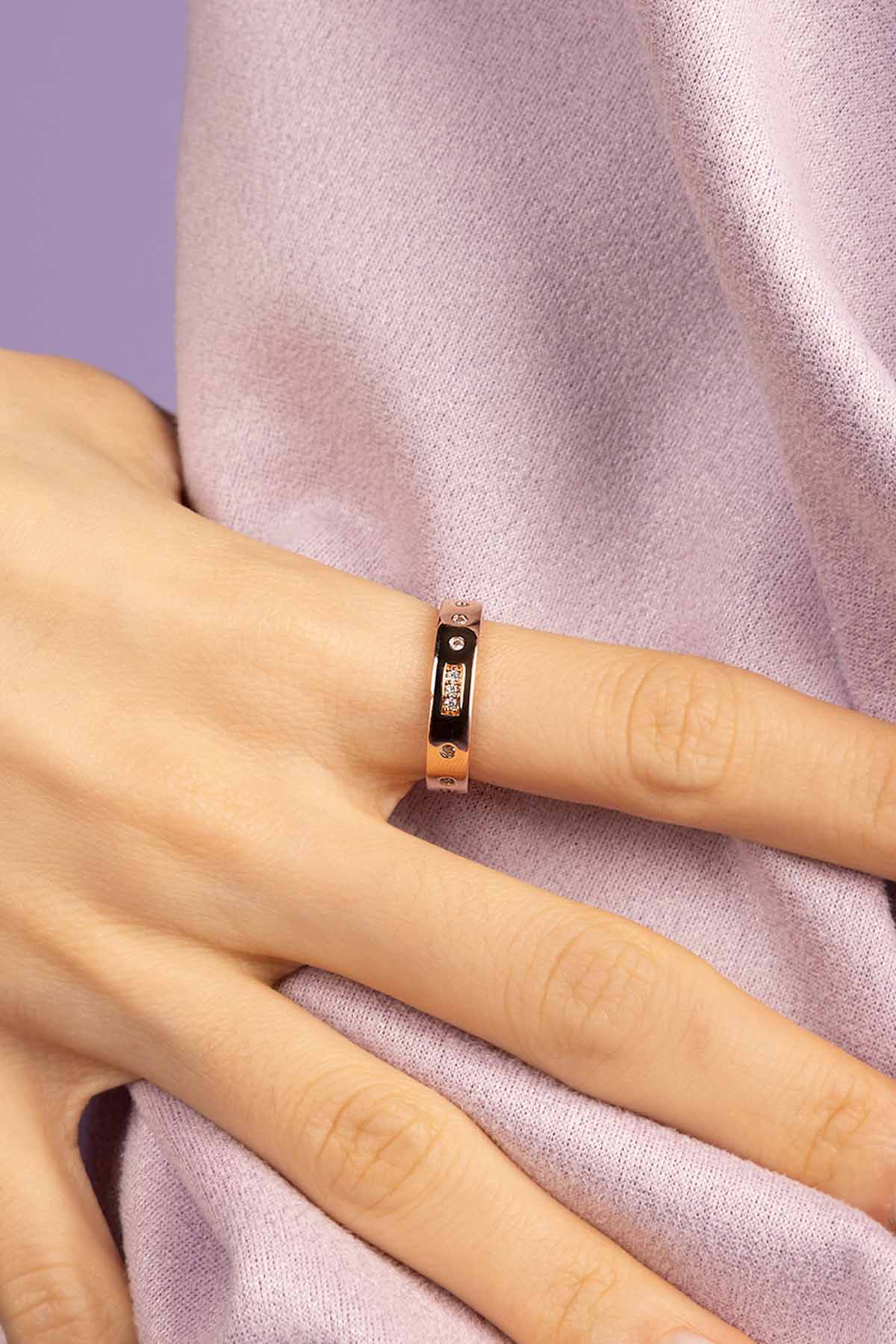 Hand wearing a ring with a white fur background