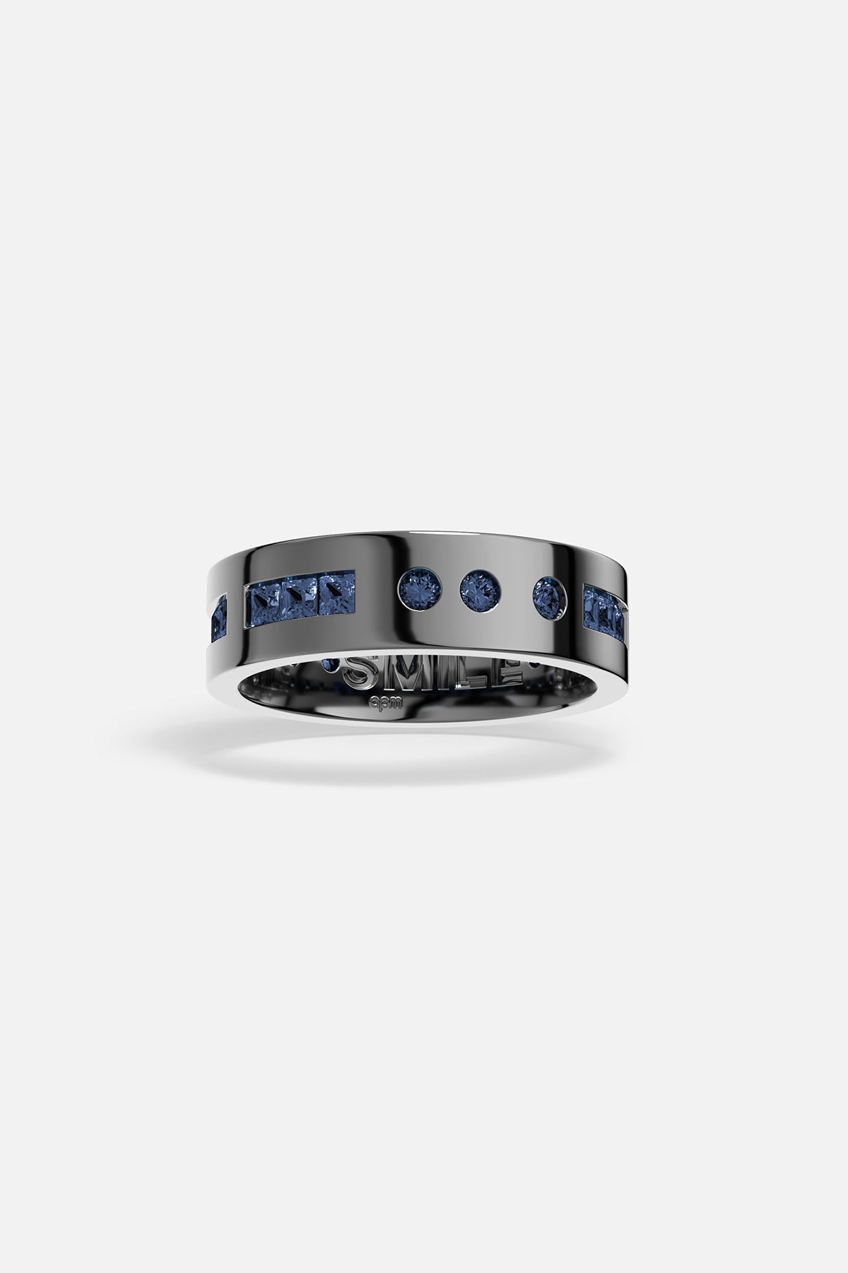 Rings APM Monaco. Silver ring with a row of blue gemstones on the top and 'SMILE' engraved inside.