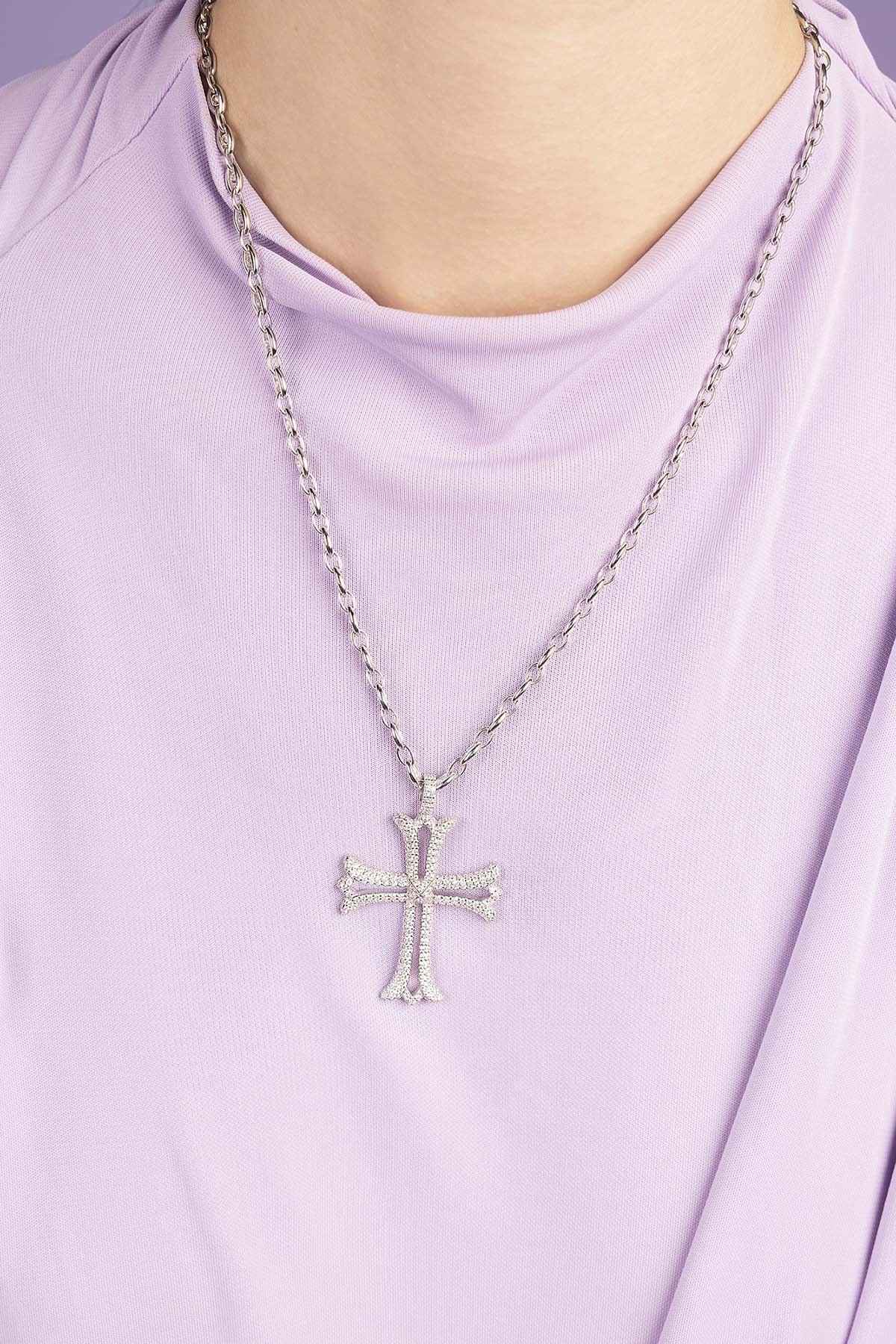 Silver cross necklace on a white background