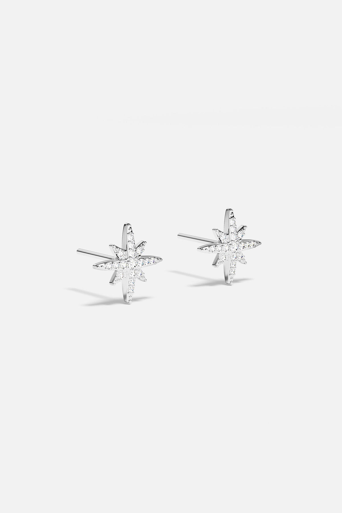 Earrings APM Monaco: silver starburst stud earrings with white stones.