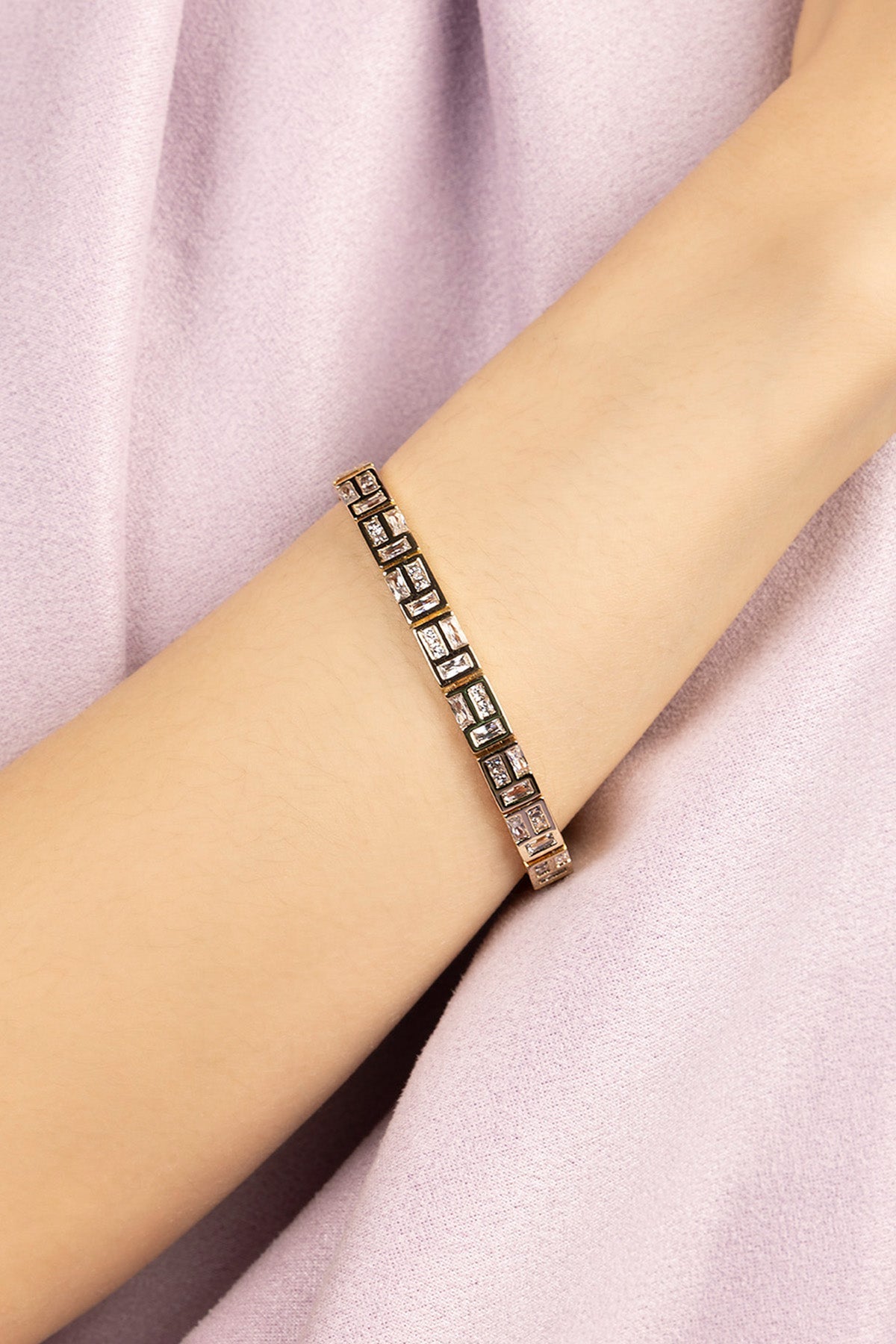 Three APM MONACO labyrinth bracelets on a wrist against a white background