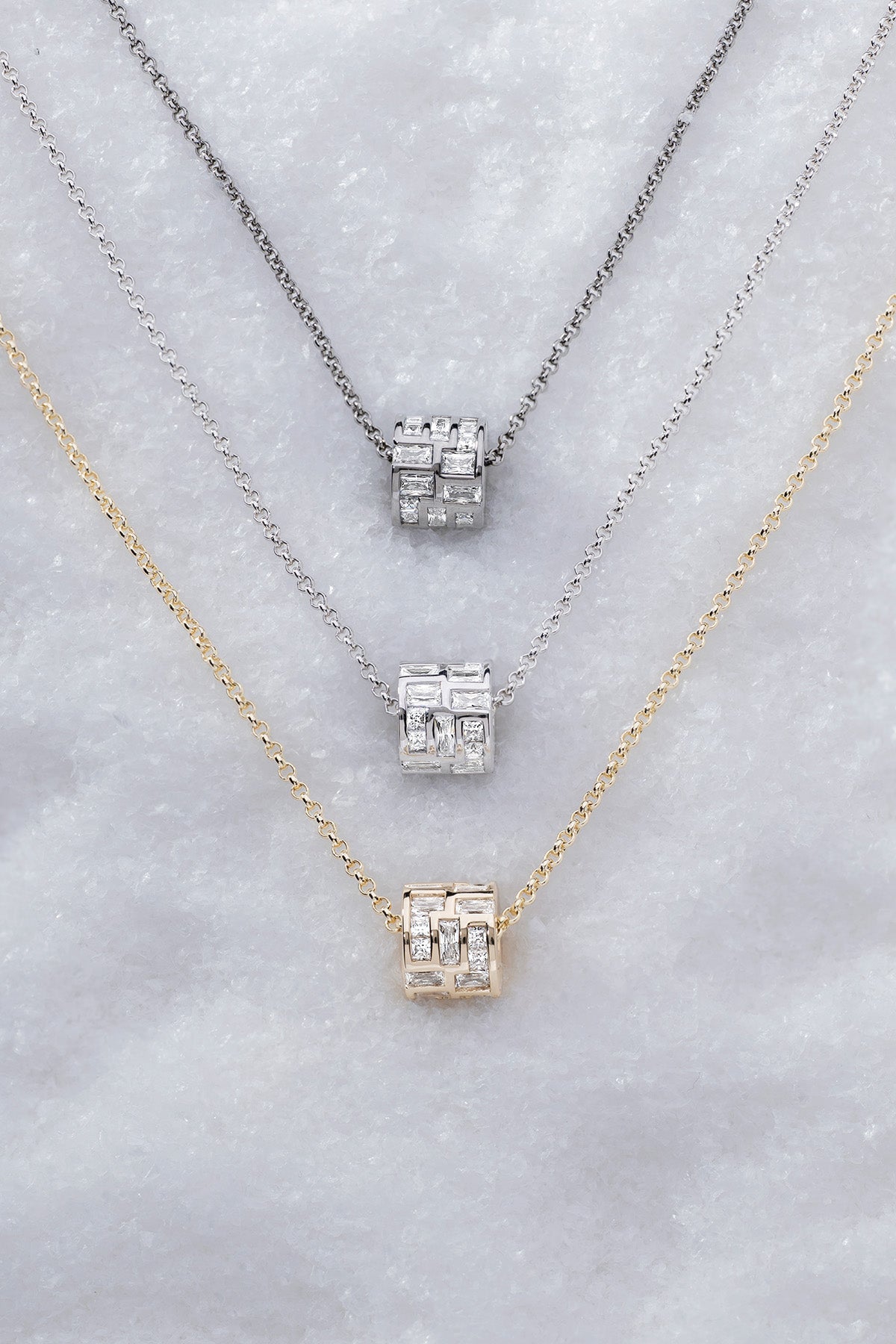 Three labyrinth chokers from APM MONACO against a textured gray background