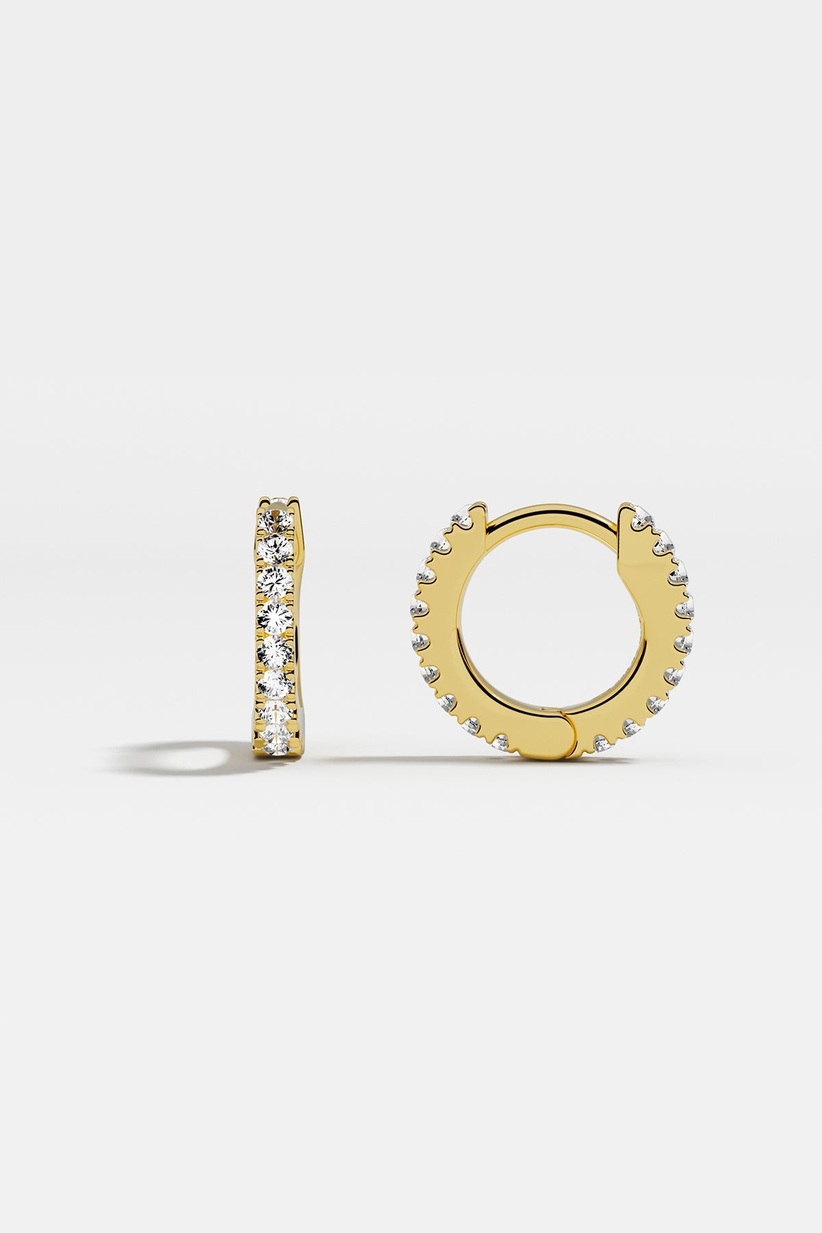 Earrings APM Monaco: yellow gold huggie hoops with white cubic zirconia.