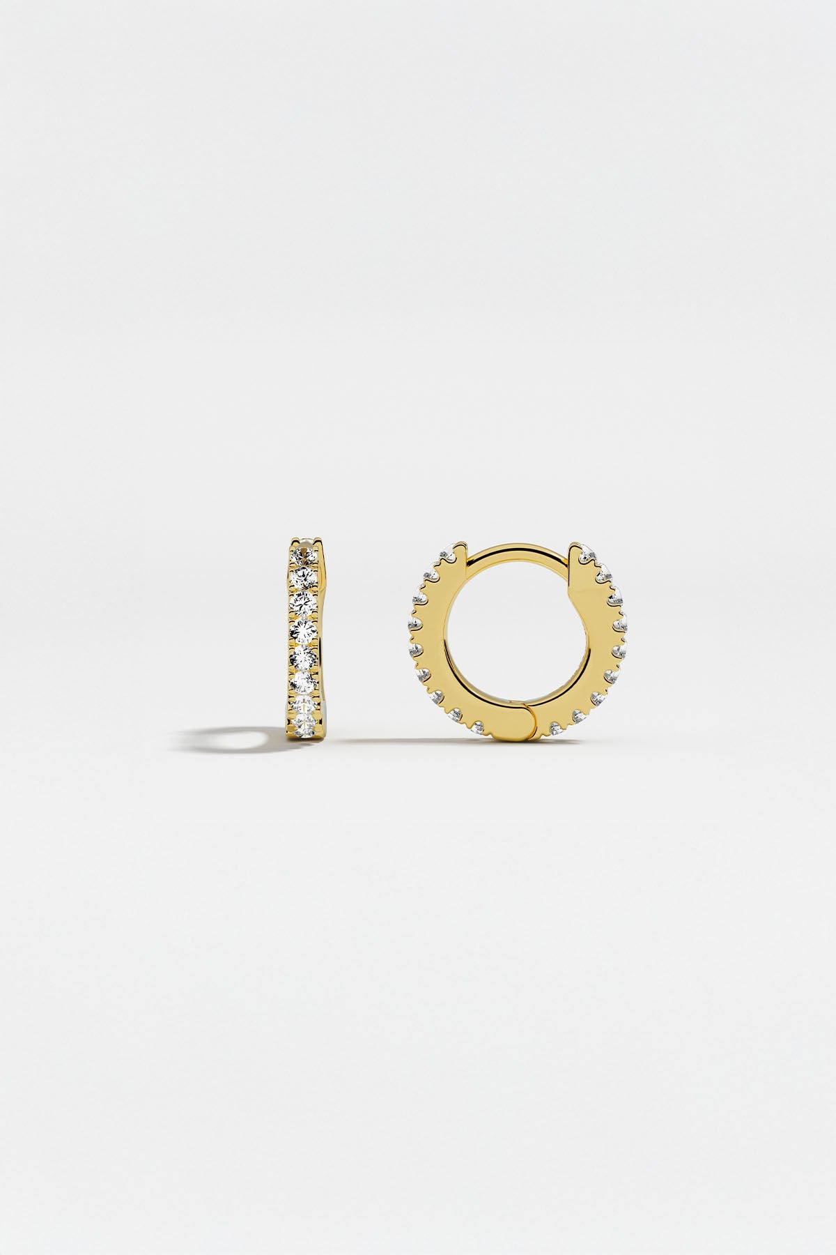 Earrings APM Monaco: yellow gold huggie hoops with white cubic zirconia.