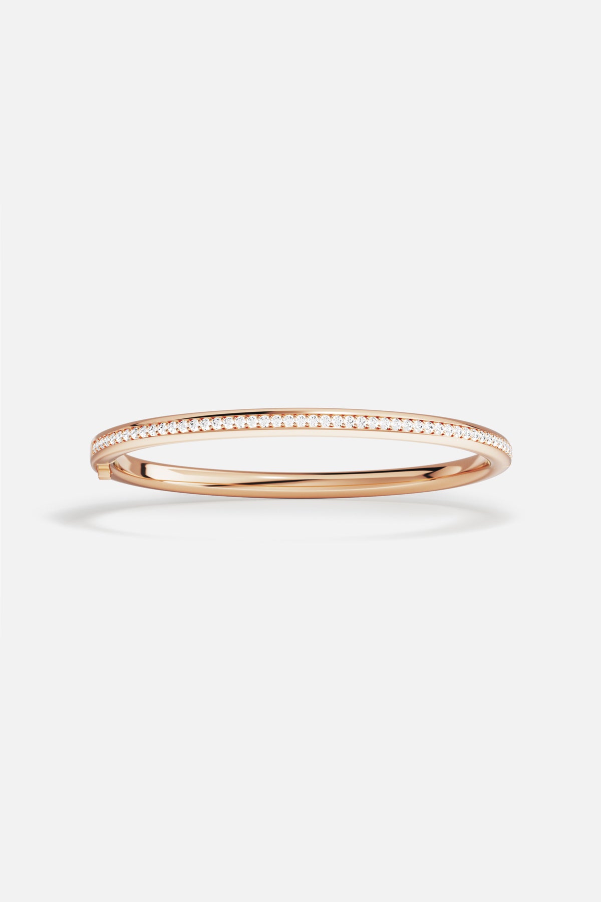 Bracelet jonc APM, ligne scintillante aux reflets rosés, élégance intemporelle au poignet.