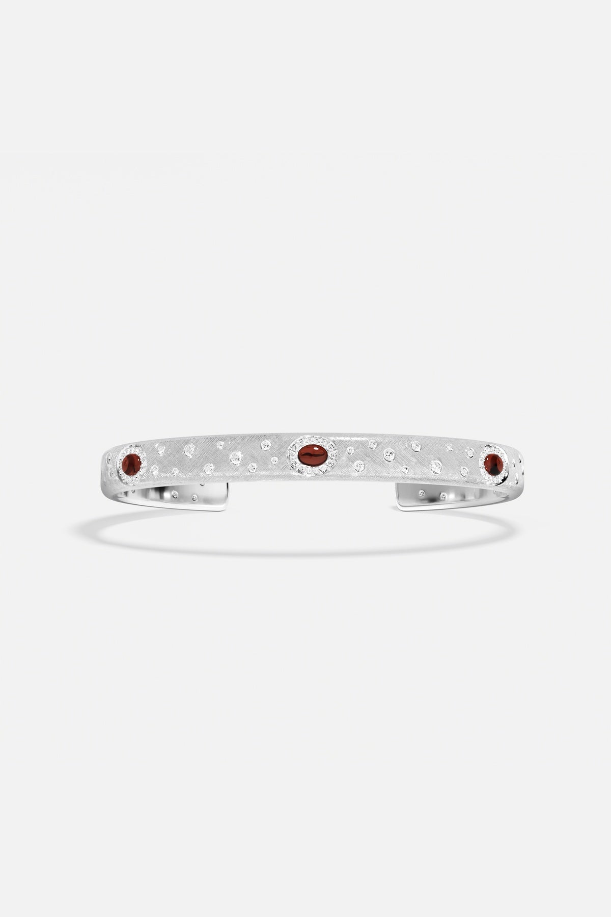 Bracelet APM en finition rhodium, éclats scintillants et touches rouges pour une allure raffinée.
