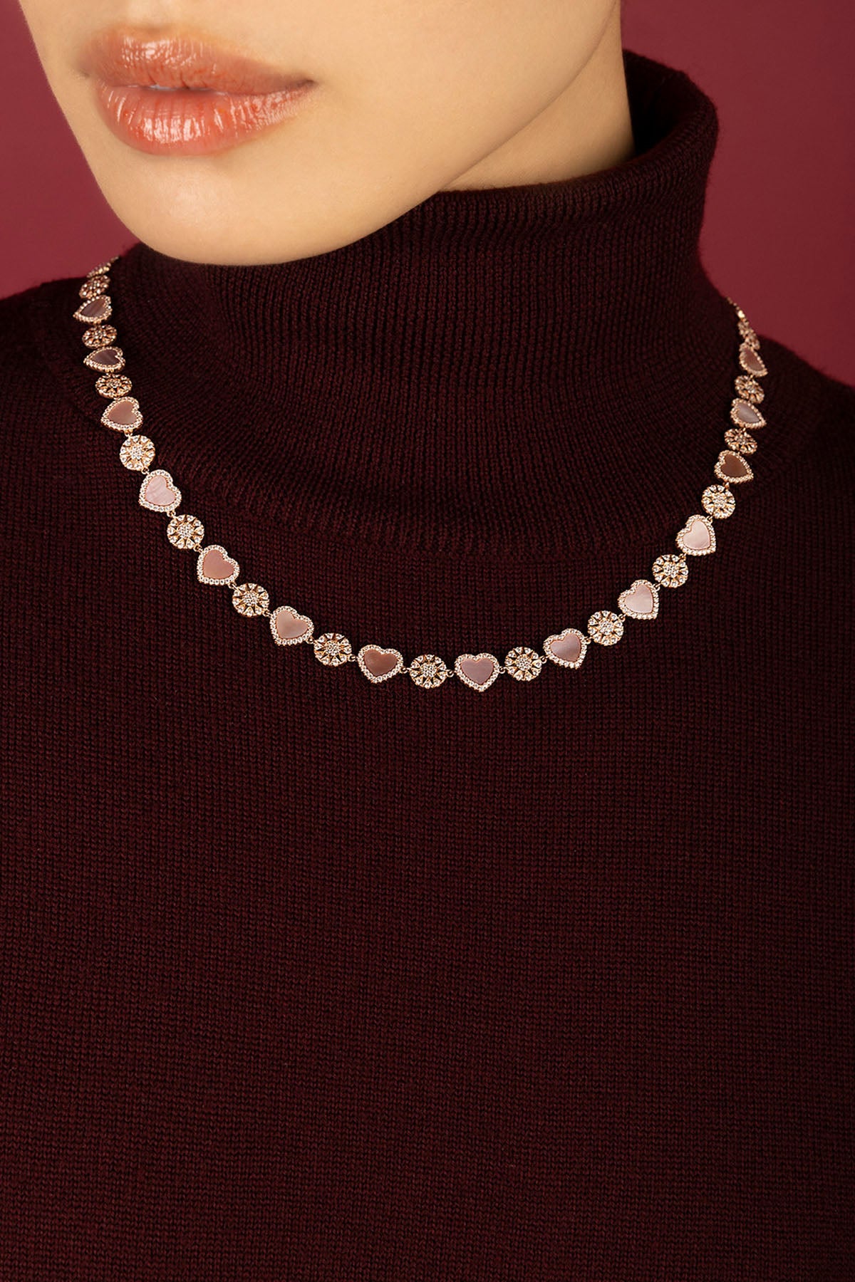 Femme portant le collier APM, une romance rose tendre au charme intemporel.