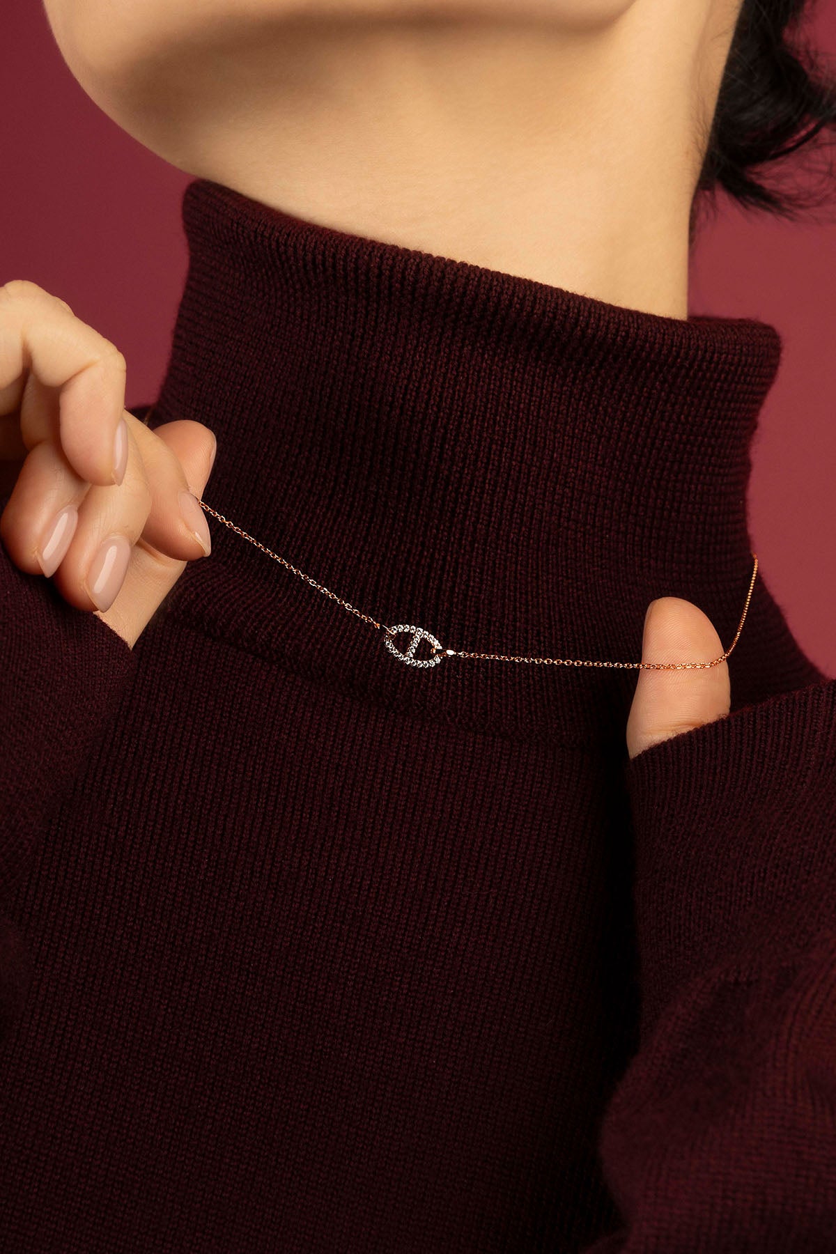 Woman wearing APM Collier Morse, une délicate signature dorée sur un col bordeaux.