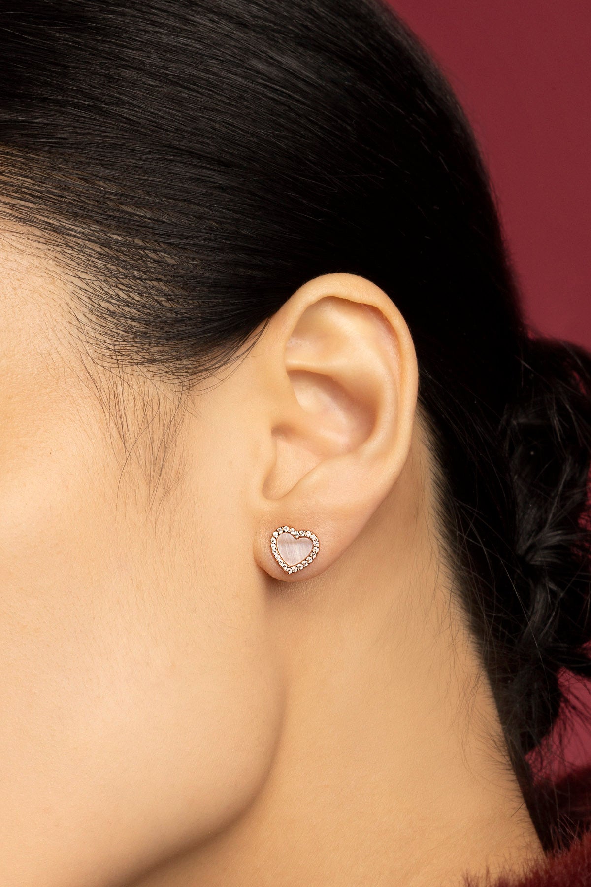 Femme portant les puces d'oreilles cœur APM, une touche romantique et lumineuse.