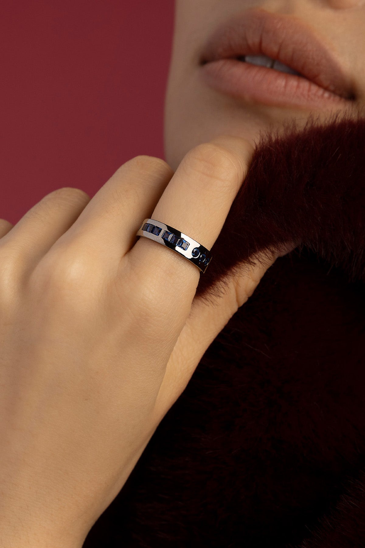 Femme portant la bague APM, finition rhodium et éclats bleus, élégance intemporelle.