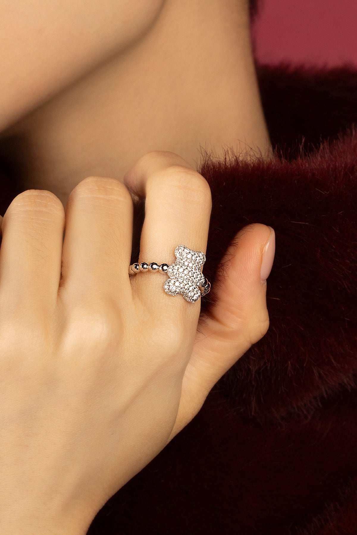 Femme portant l'APM Ours Ring, une douceur scintillante au bout des doigts.
