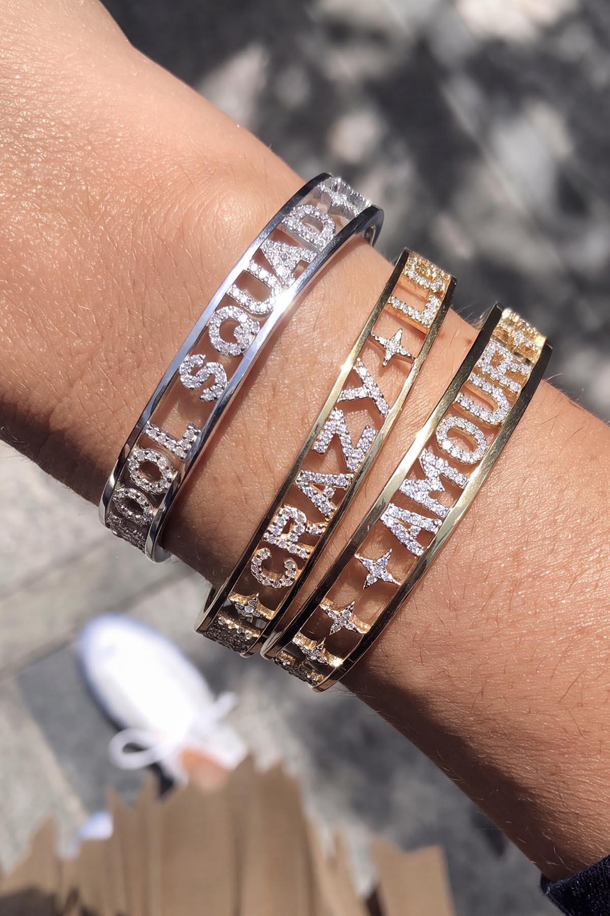 Femme portant des Bracelets APM Monaco, un empilement lumineux aux messages scintillants.
